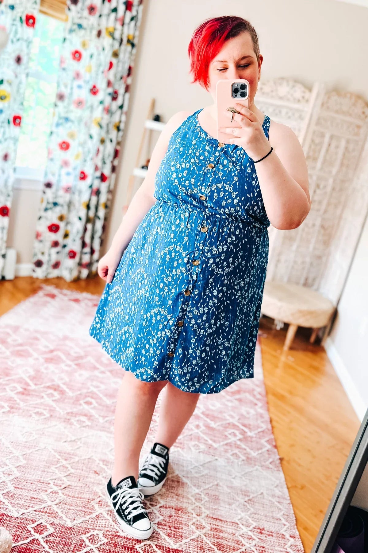 Woman wearing a blue floral dress standing indoors