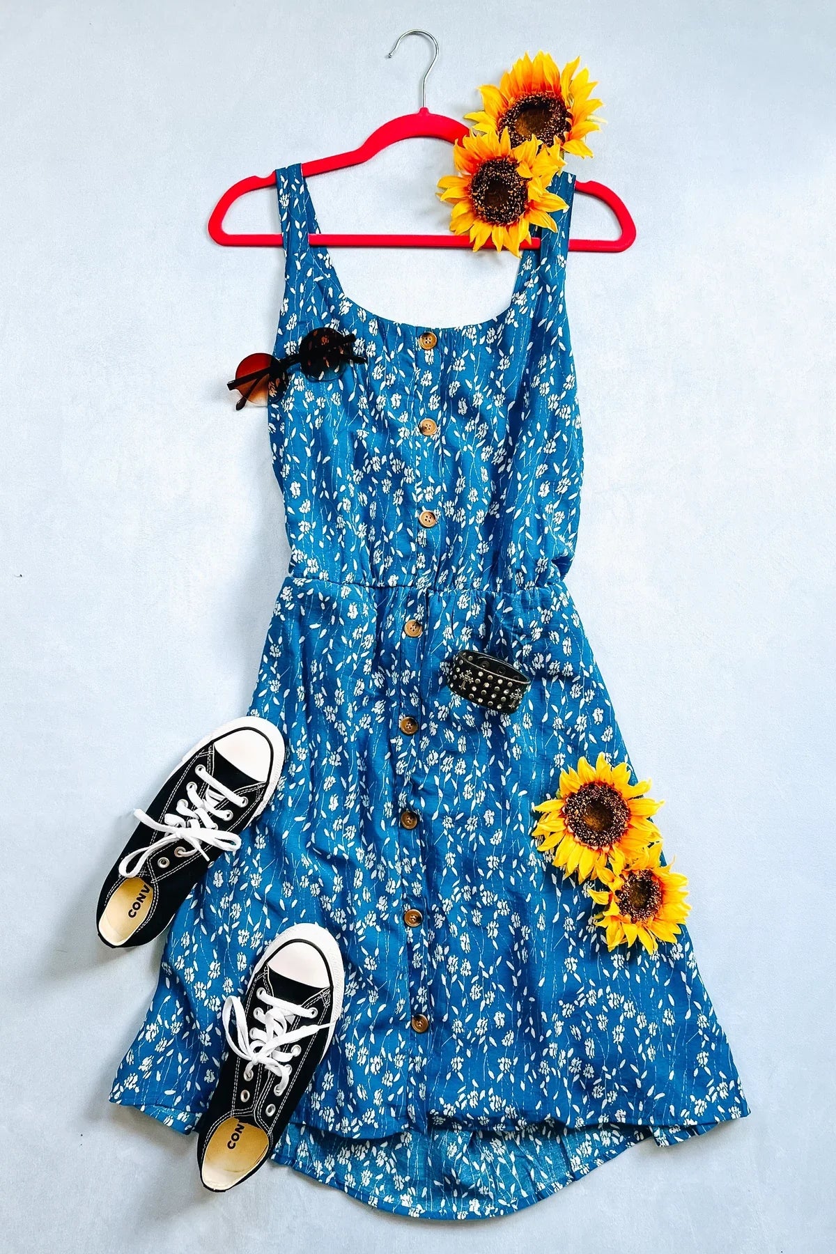 A flat lay shot of a blue floral summer dress.