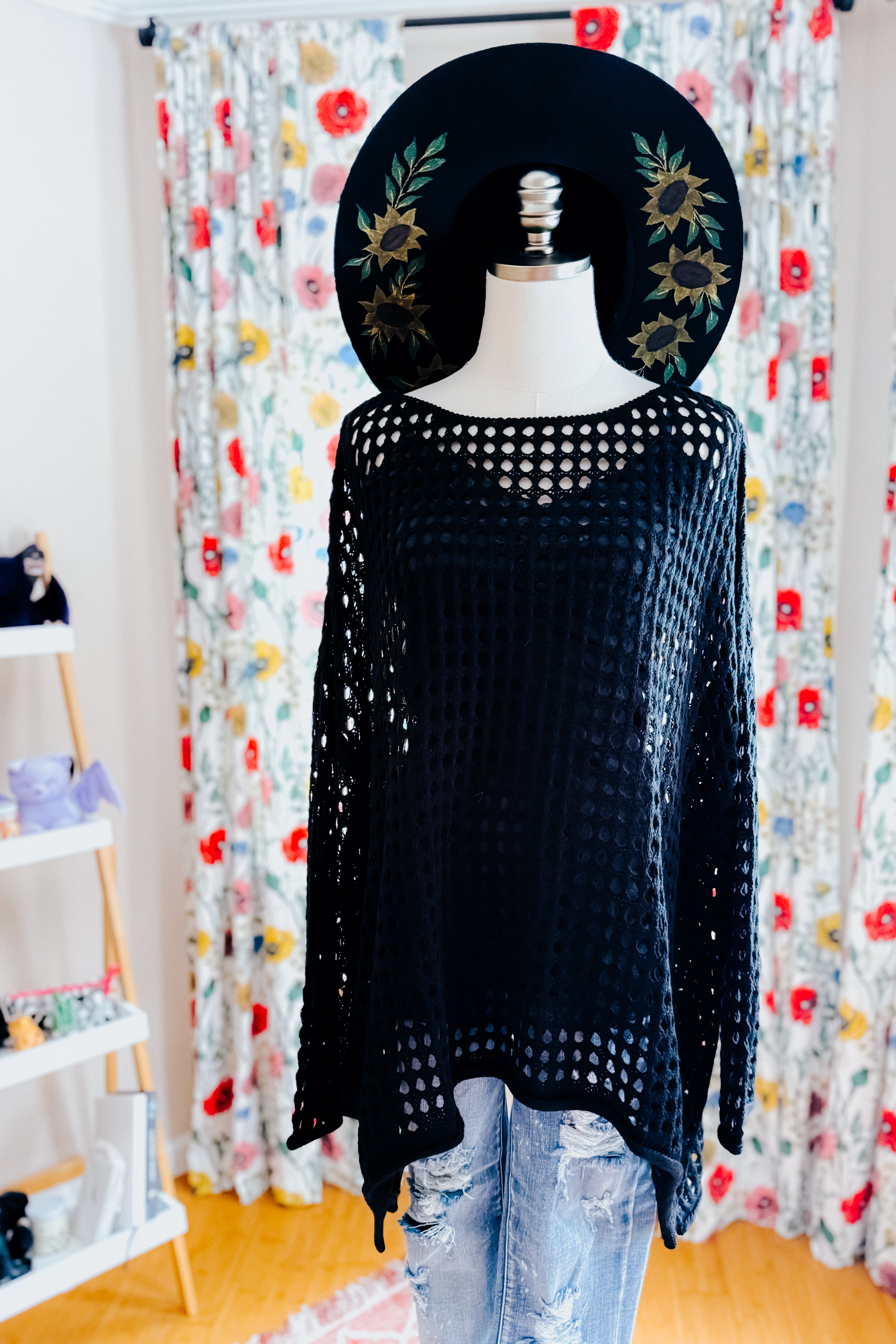 Mannequin wearing Ask Anyway black fishnet sweater with long sleeves and floral embroidered black wide-brim hat indoors
