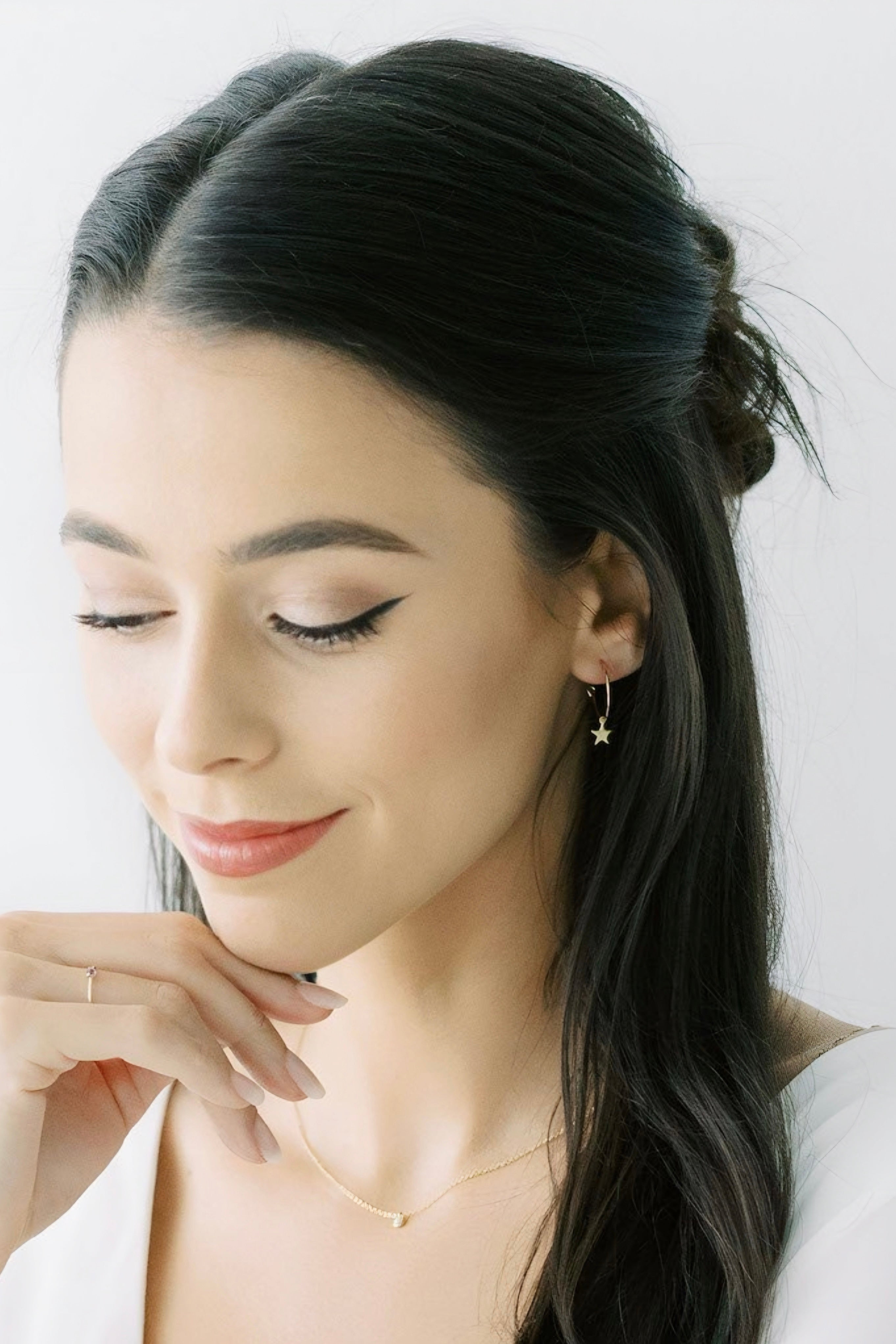 Young woman with sleek dark hair wearing delicate gold star charm hoop earrings AstraMagicCharmStarHoopEarrings9.jpg