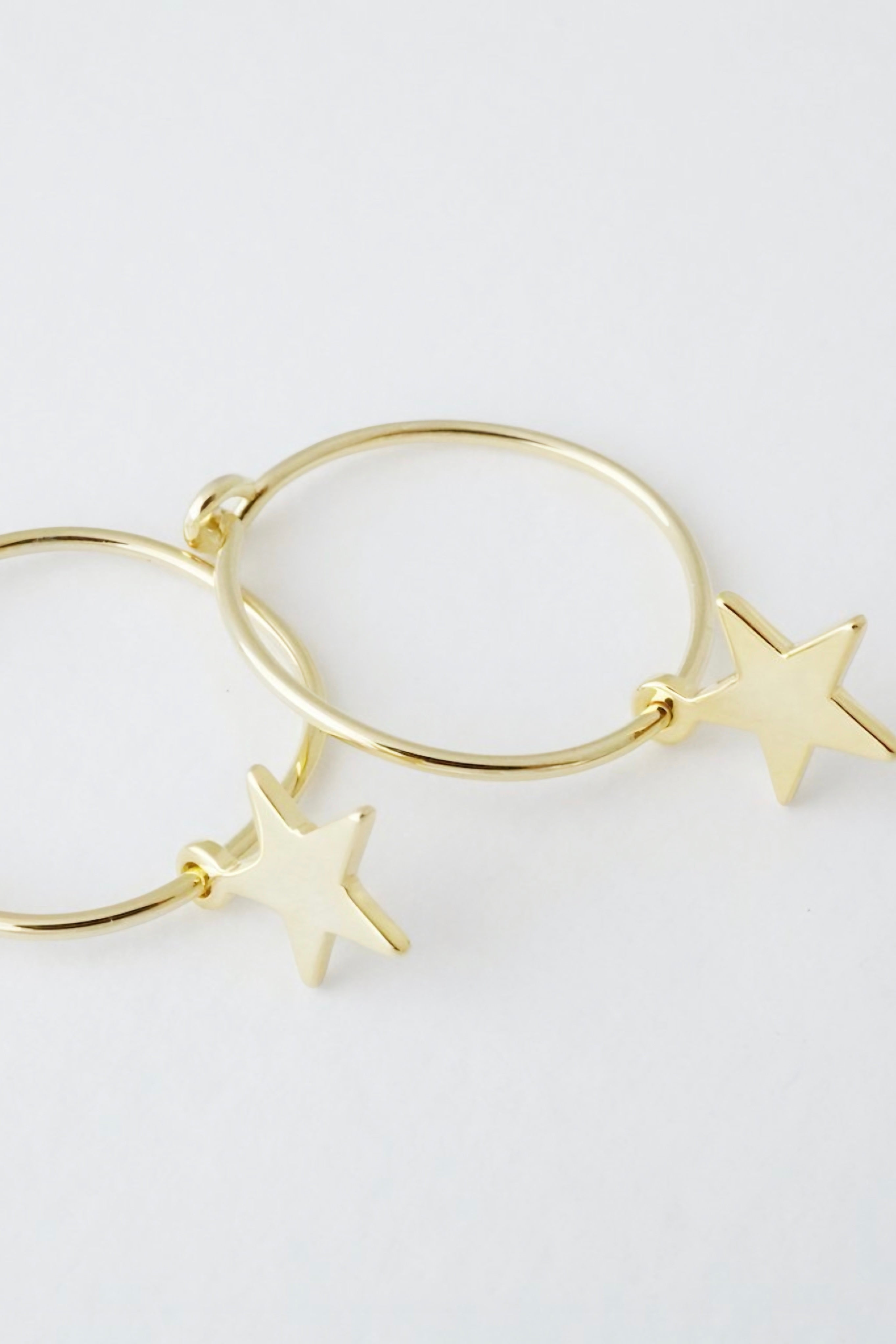 Minimalist gold hoop earrings featuring polished star charms on a clean white background AstraMagicCharmStarHoopEarrings7.jpg