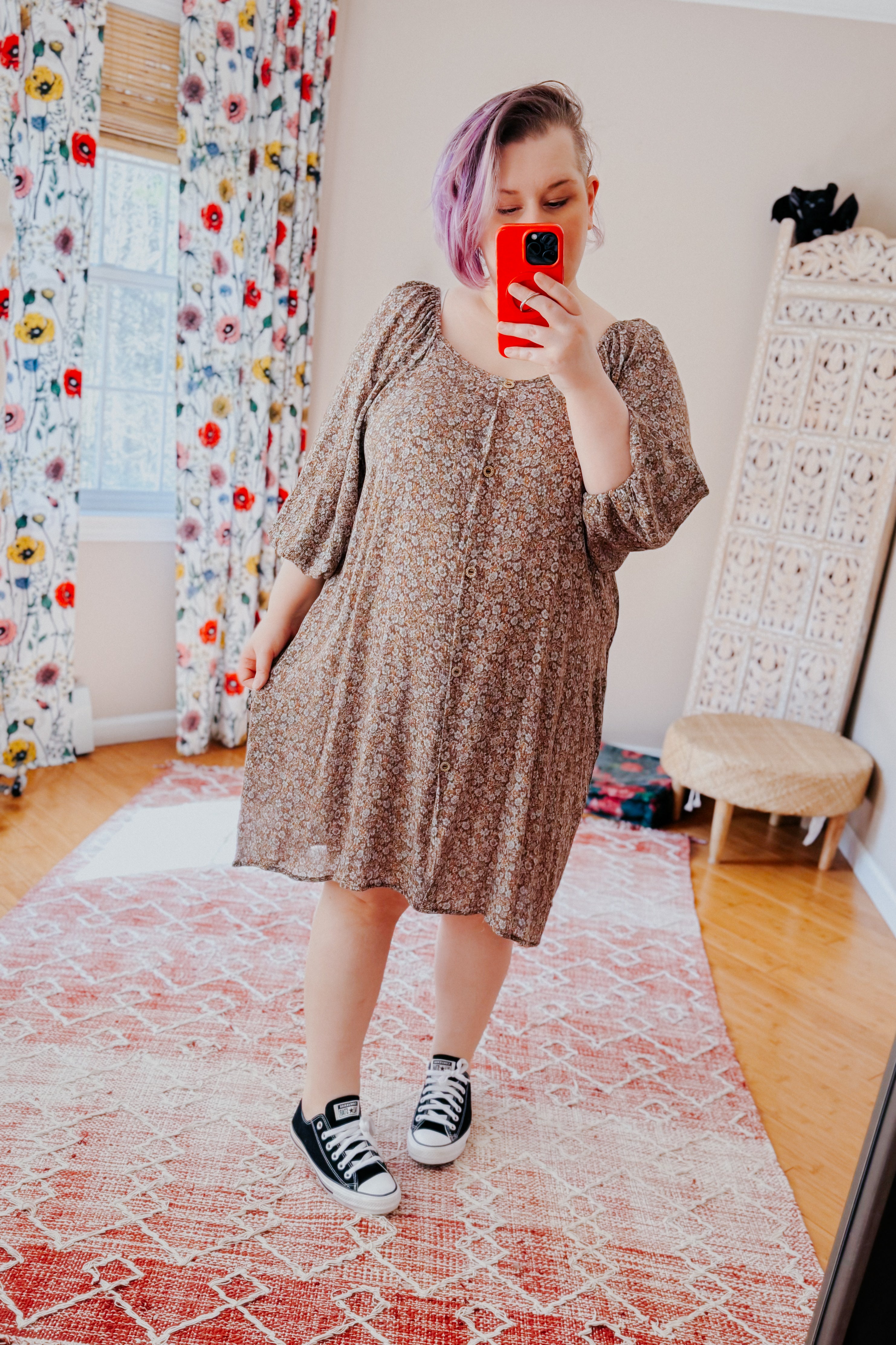 Woman with lavender hair taking selfie wearing Autumn Feels Floral Dress with buttons and puff sleeves in cozy room setting