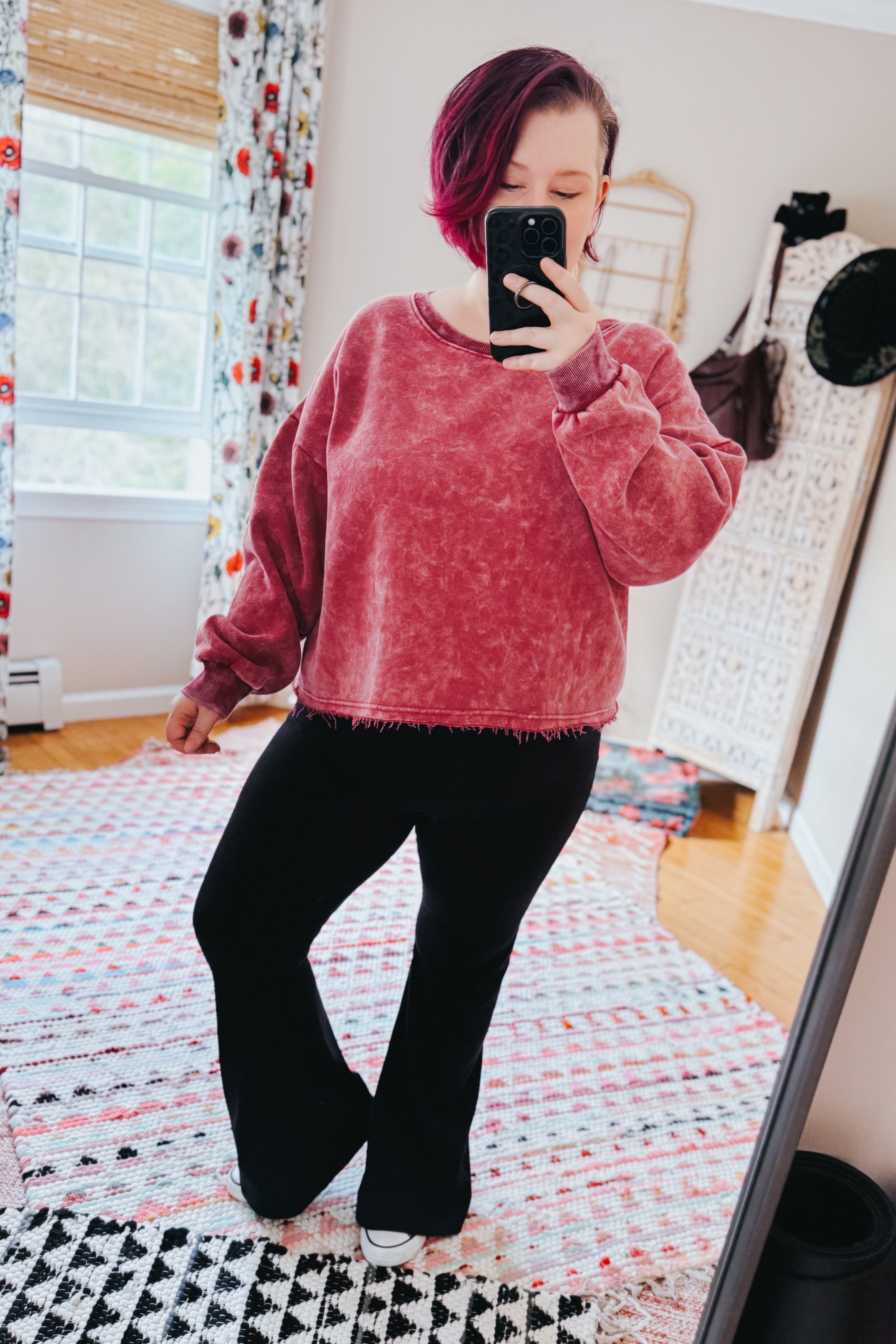 Person with short magenta hair wearing Bad Company Acid Wash Cropped Pullover in berry, taking mirror selfie indoors