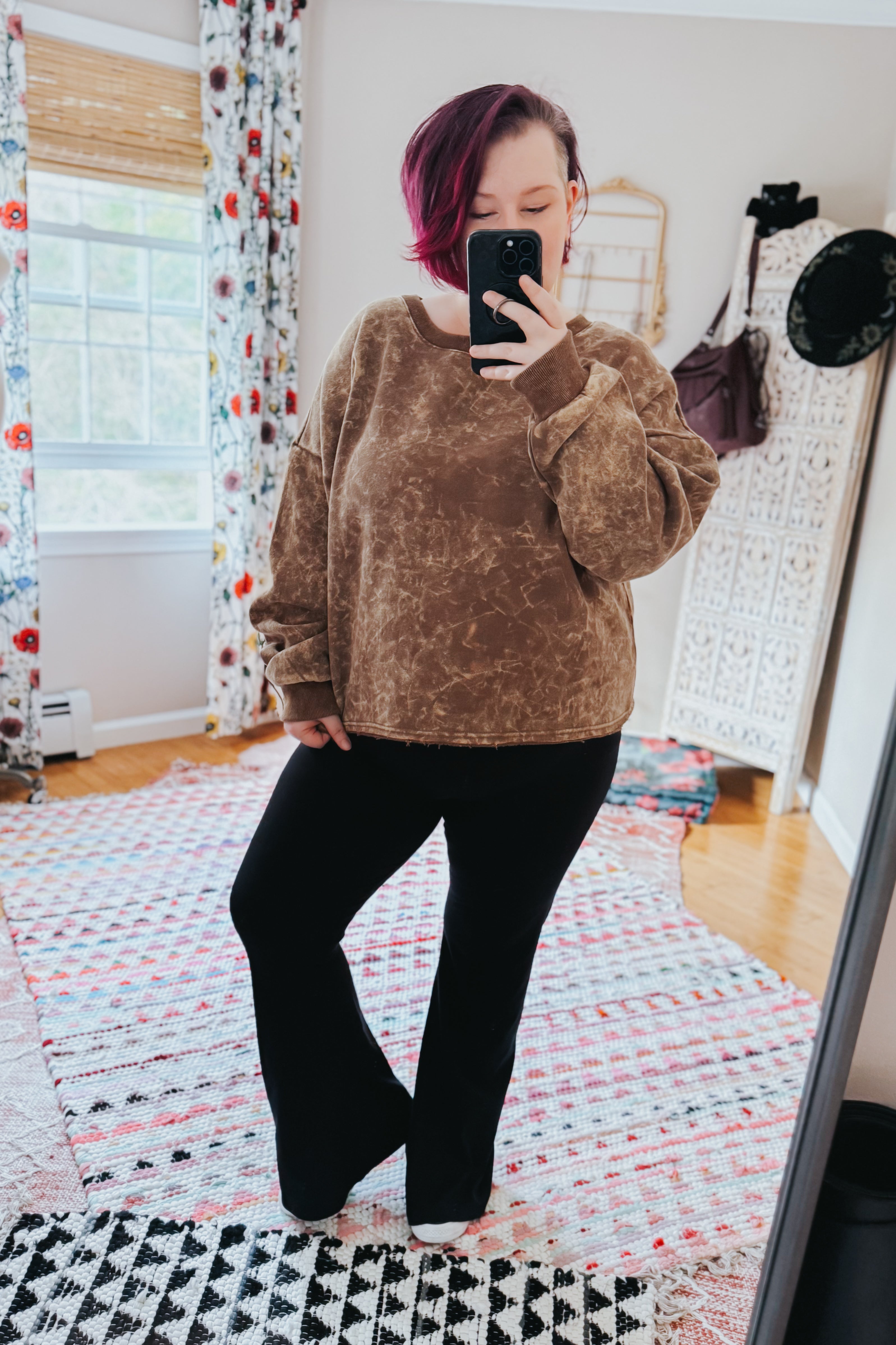 Person taking mirror selfie wearing mocha acid wash cropped pullover with relaxed fit and black flare pants in cozy room, gallery 0