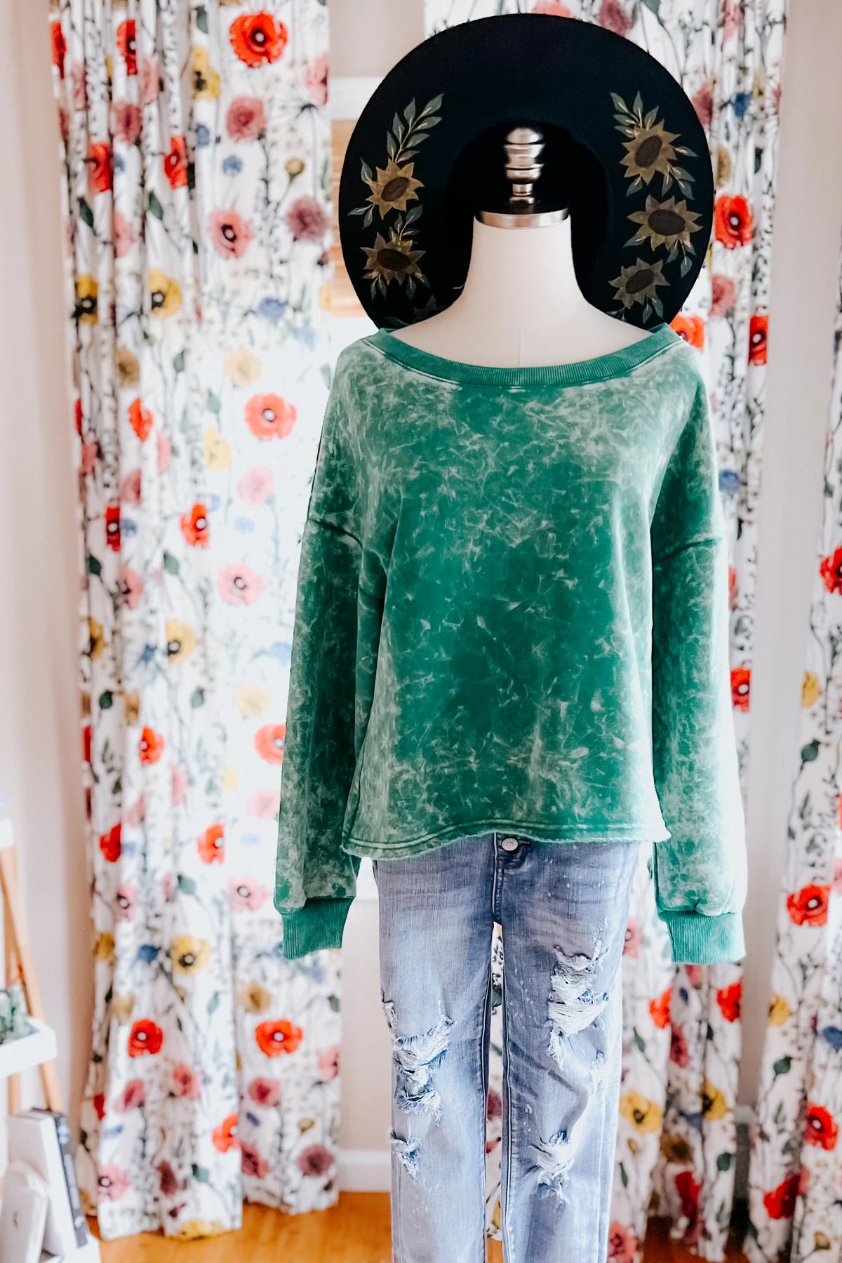 Sea green acid wash cropped pullover on mannequin paired with distressed light wash jeans and black floral hat indoors, IMG_9837.webp