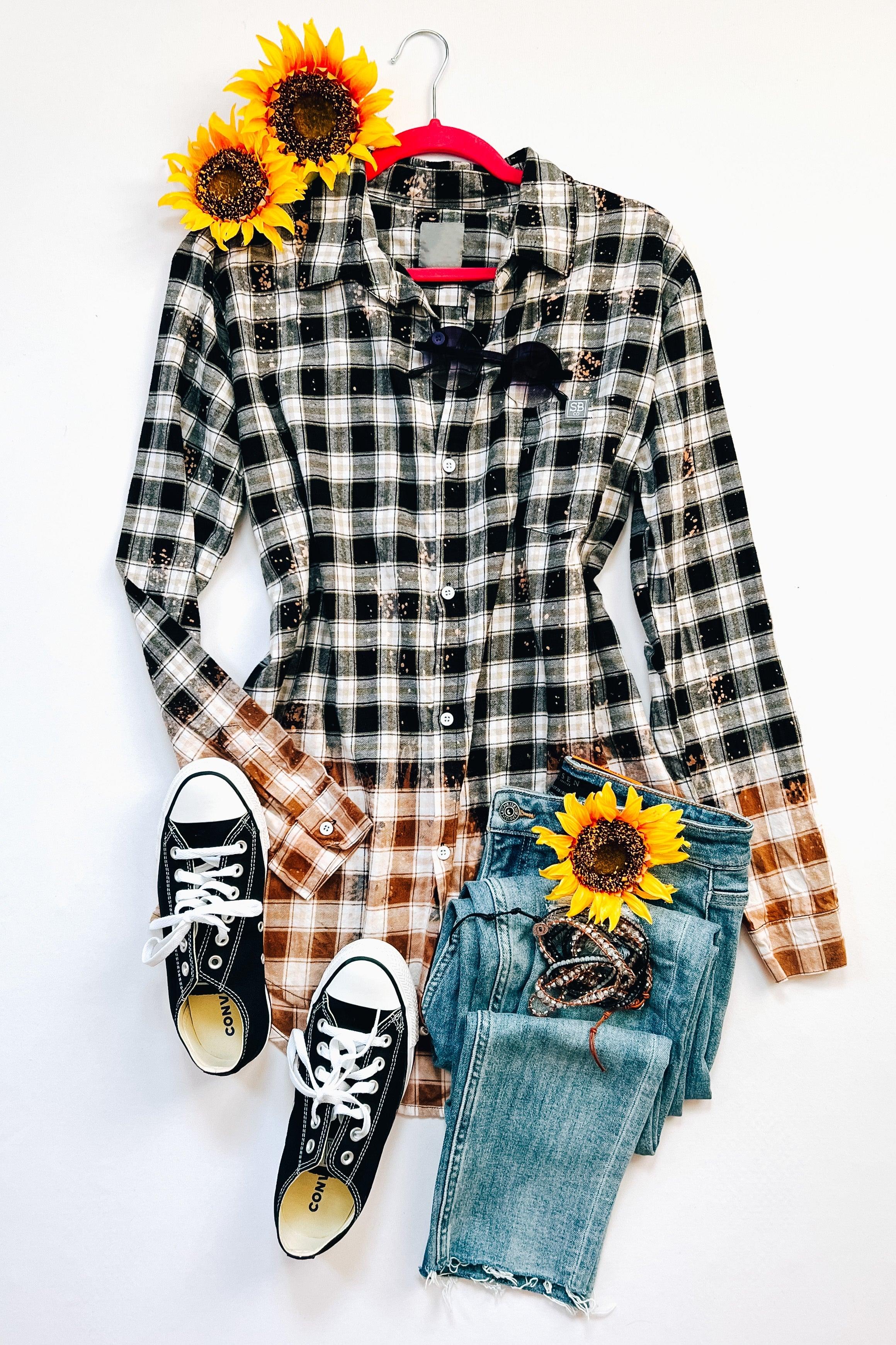 Bleached black and white plaid flannel shirt styled with blue jeans, black sneakers, and sunflowers on white background