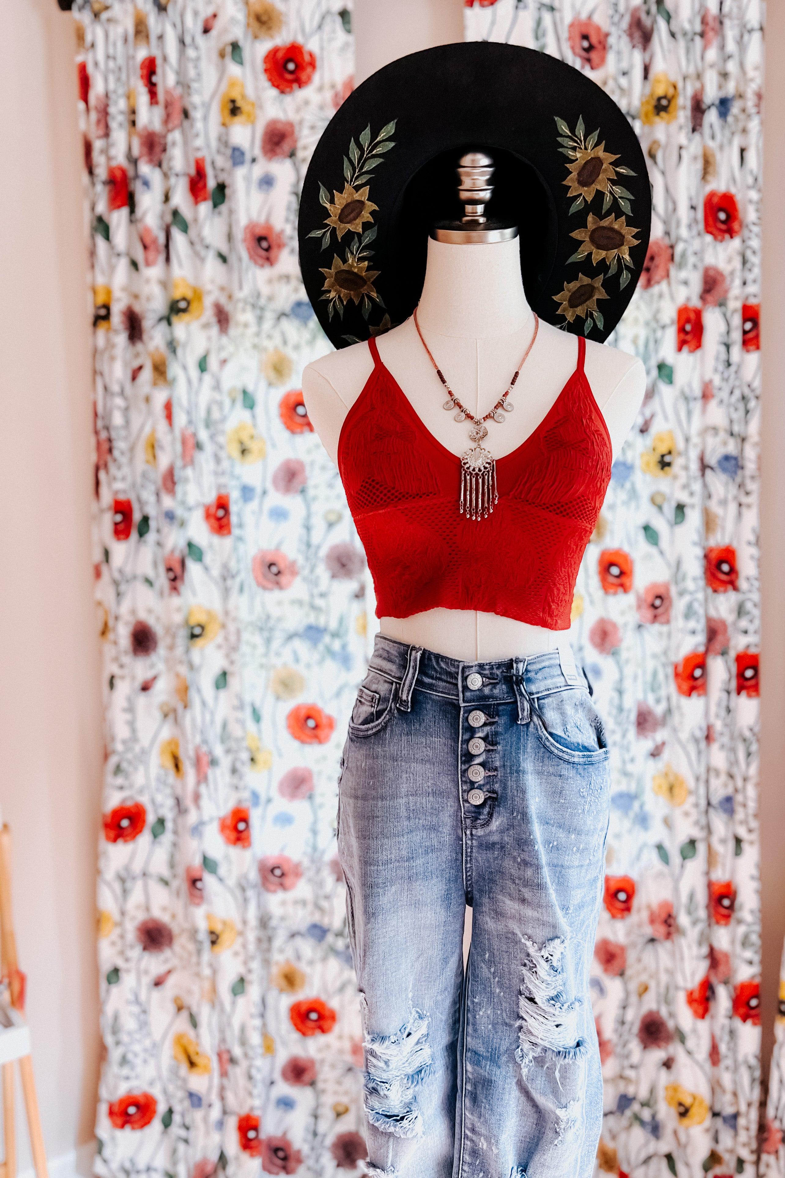 Red textured seamless padded brami styled on mannequin with layered silver necklace and wide-brim black hat with sunflower embroidery