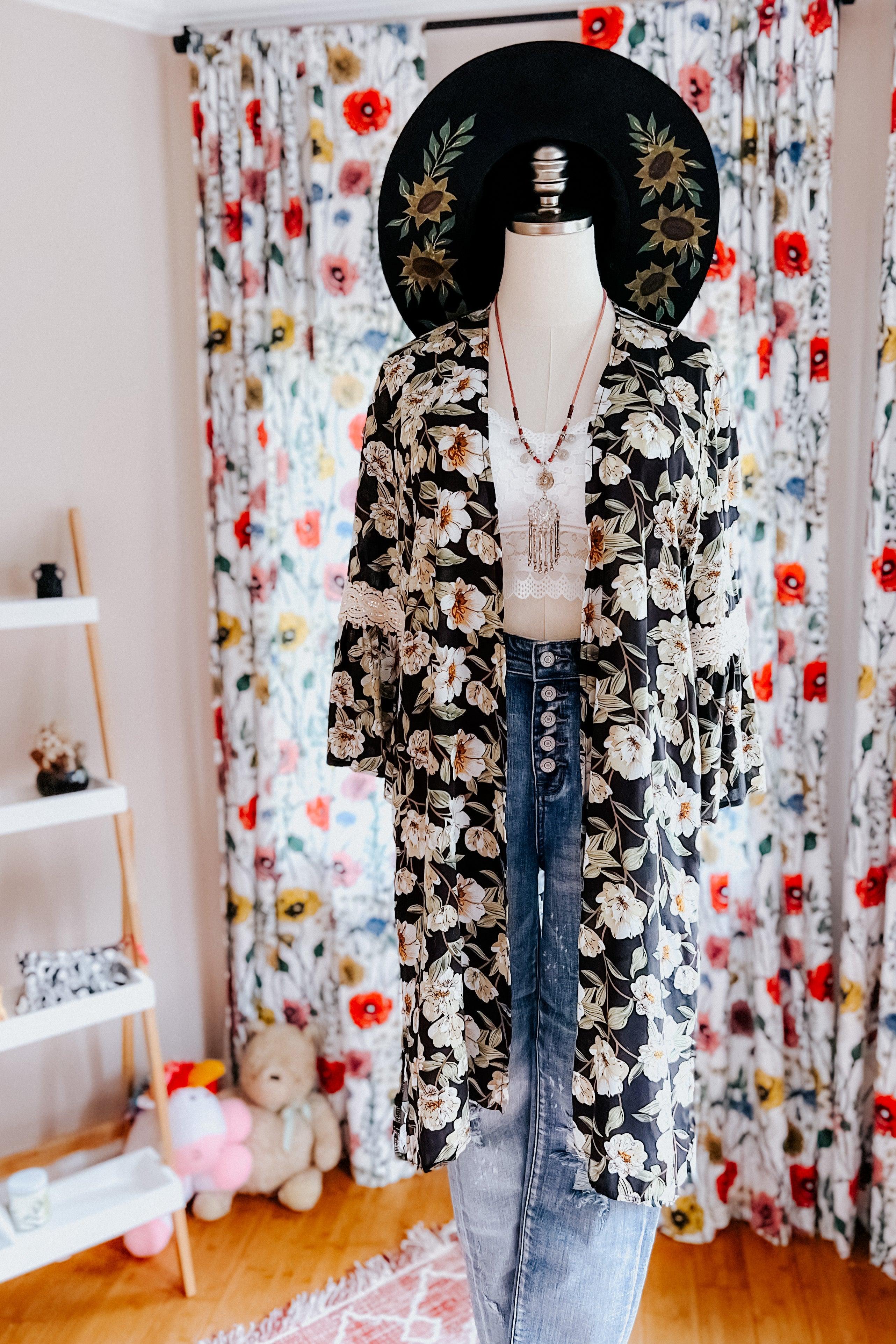 Mannequin dressed in floral print 3/4 sleeve duster over white lace crop top and high-waisted button fly jeans indoors