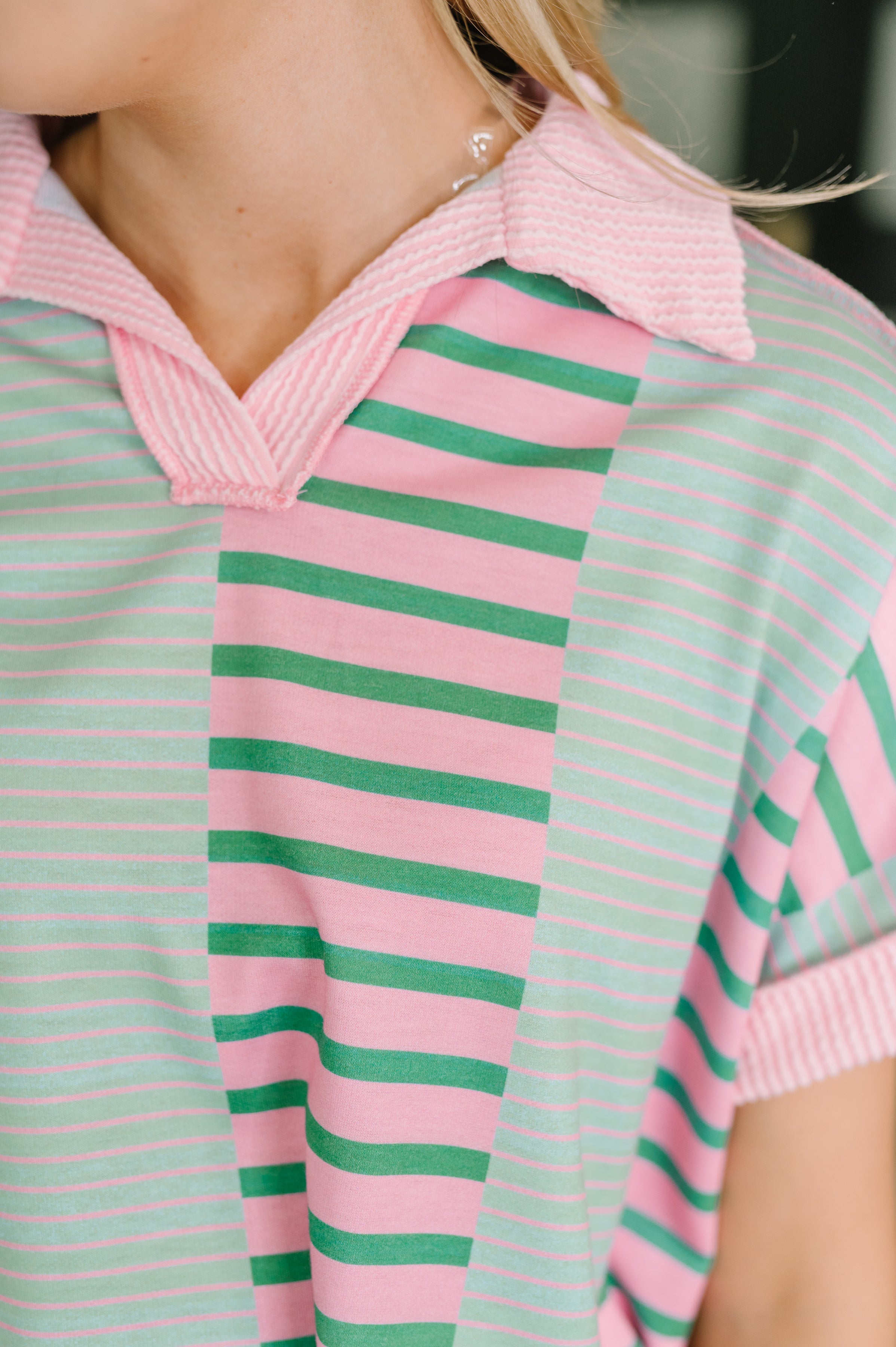 Close-up of mint and pink striped collared color block top with soft plush fabric and relaxed fit design