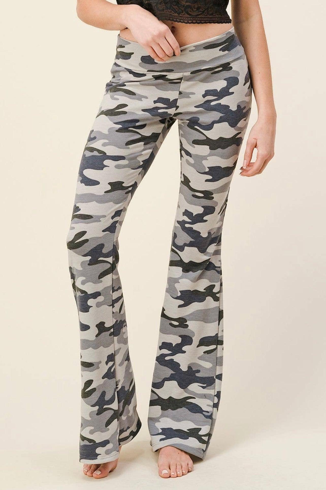 Close-up of high-rise flare pants with grey and navy blue camouflage print worn barefoot by a standing model