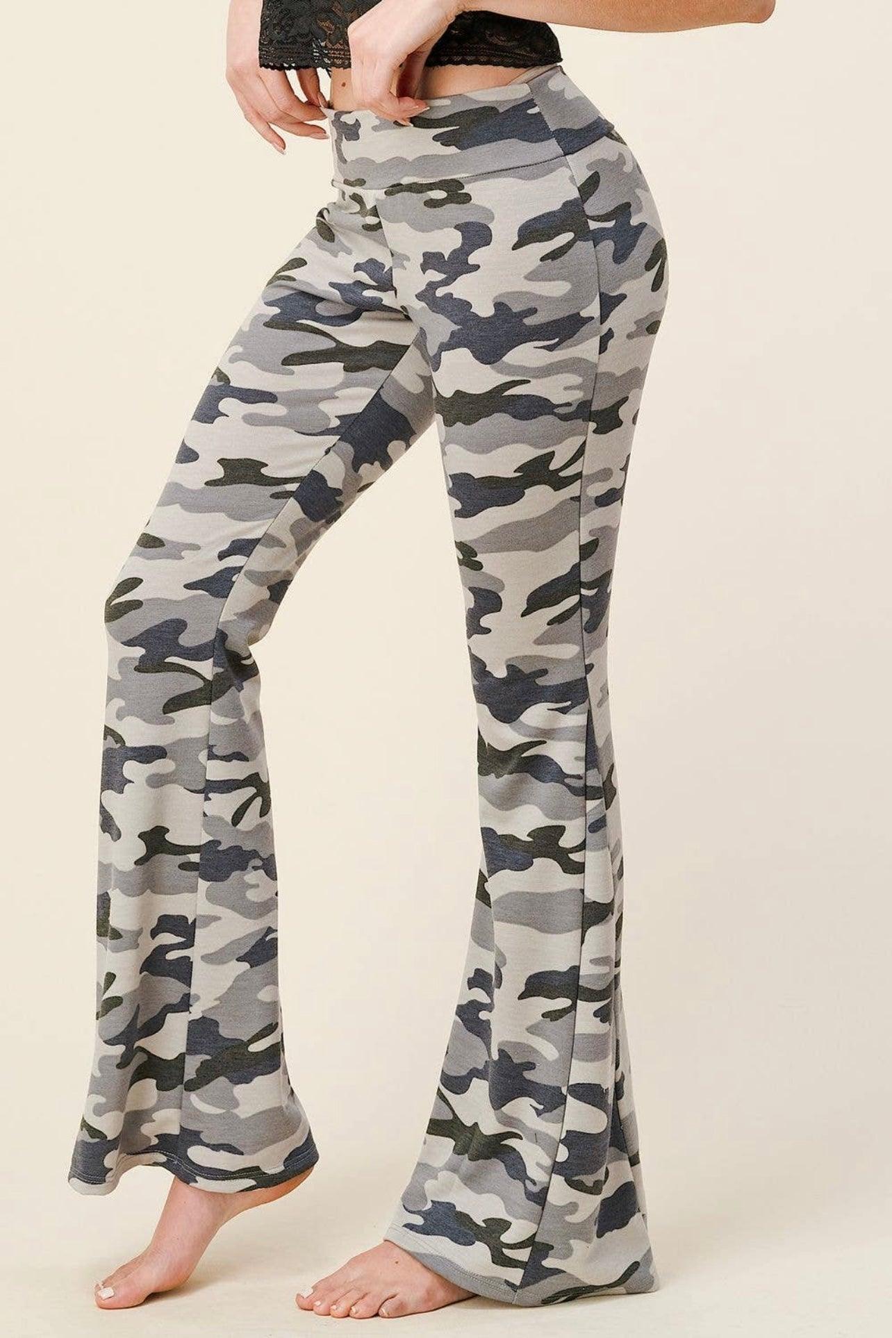 Close-up of high-waisted flare pants in grey and navy blue camouflage pattern worn by a model standing barefoot