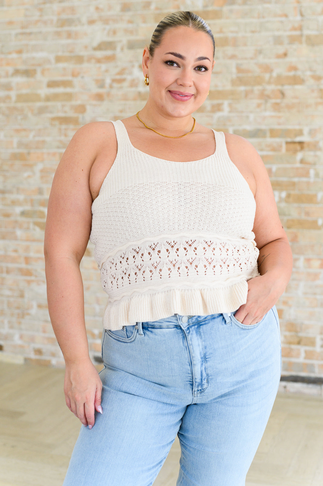 Plus size woman wearing cream knit Day Dancing Ruffle Tank Top with lace detail and ruffle hem standing indoors