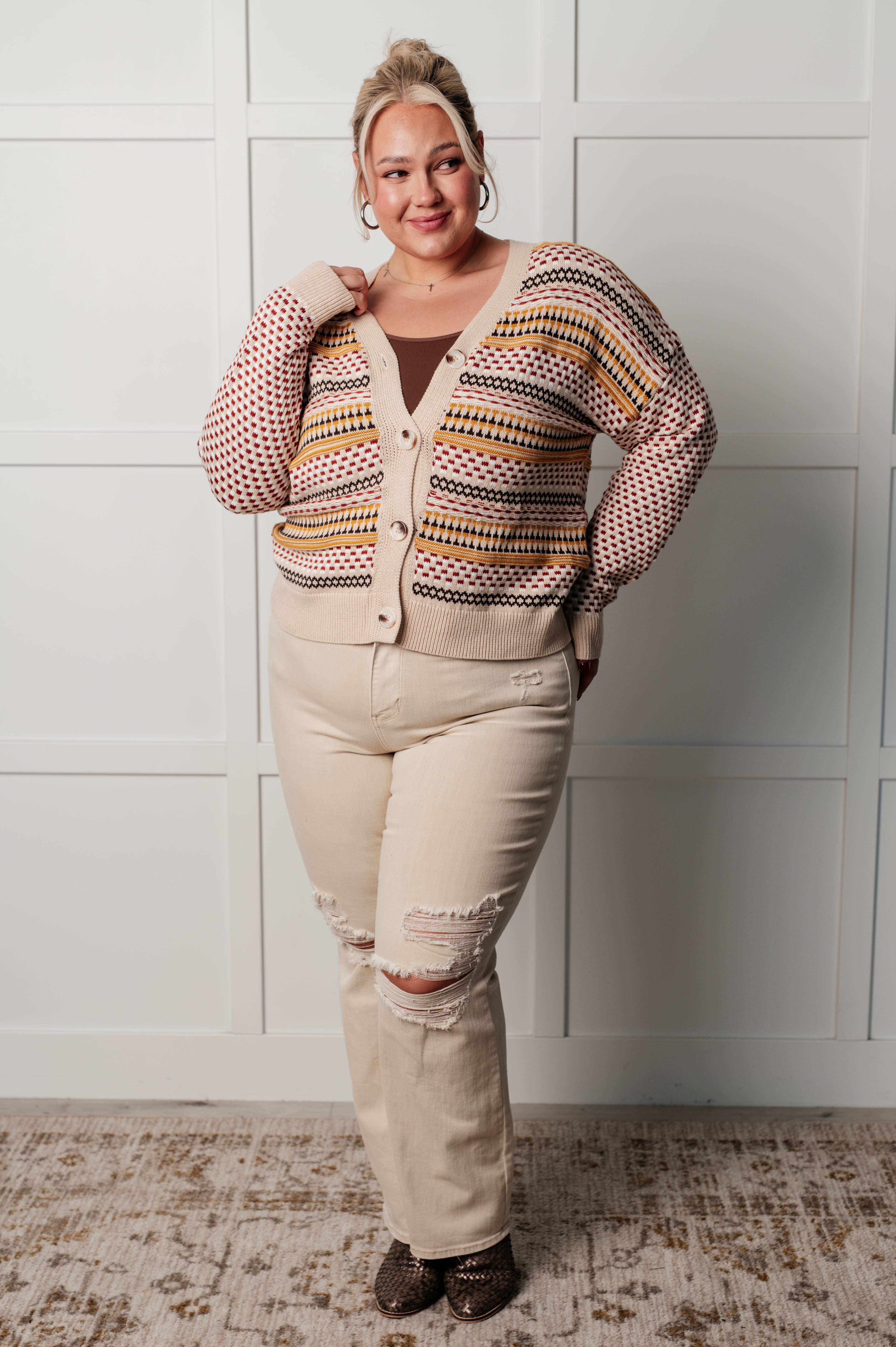 Plus-size woman with blonde hair styled up wearing striped Effortless Elements cardigan with beige pants indoors