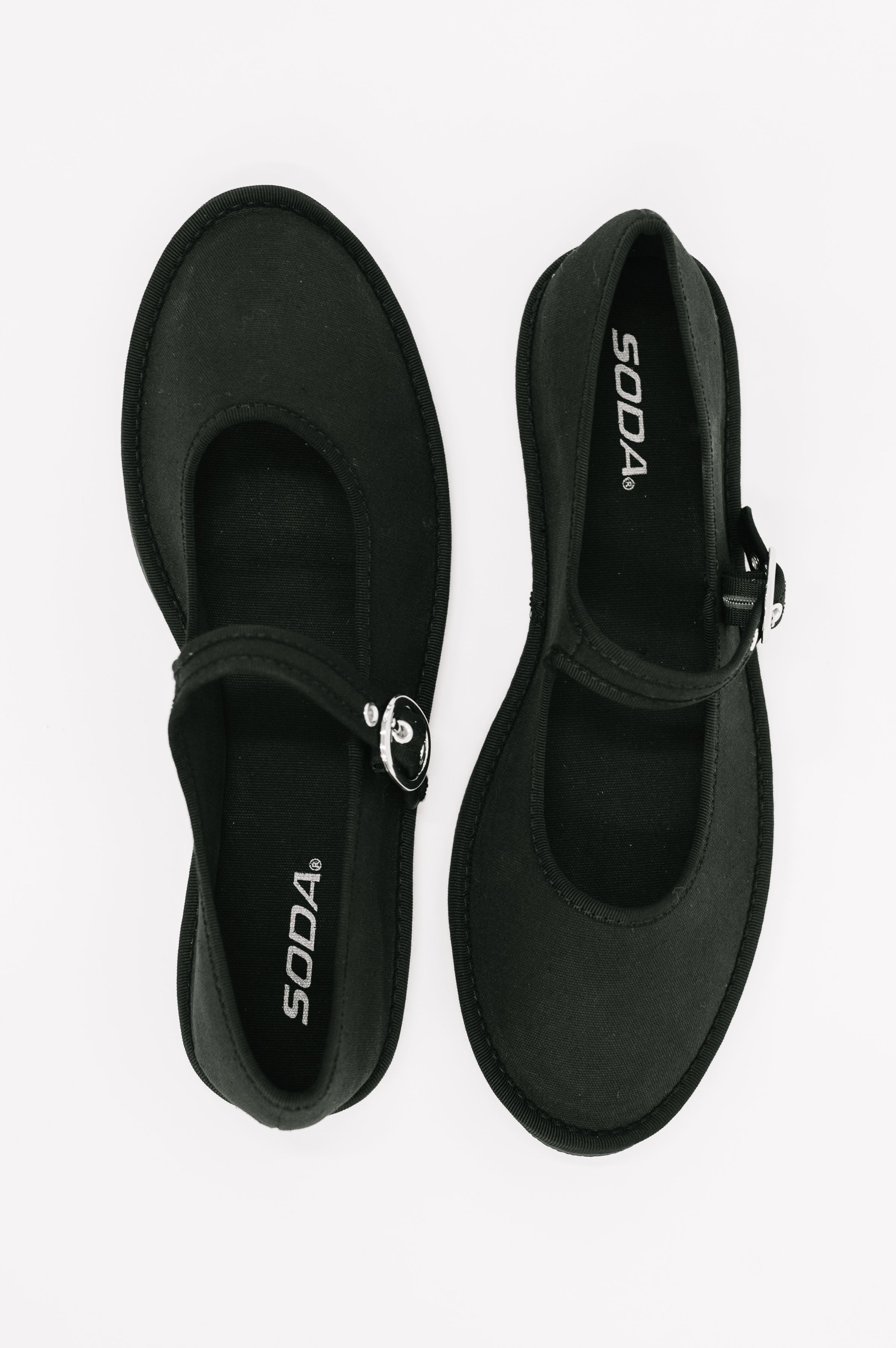 Pair of black buckle flats with rounded toes and adjustable straps displayed on a white background