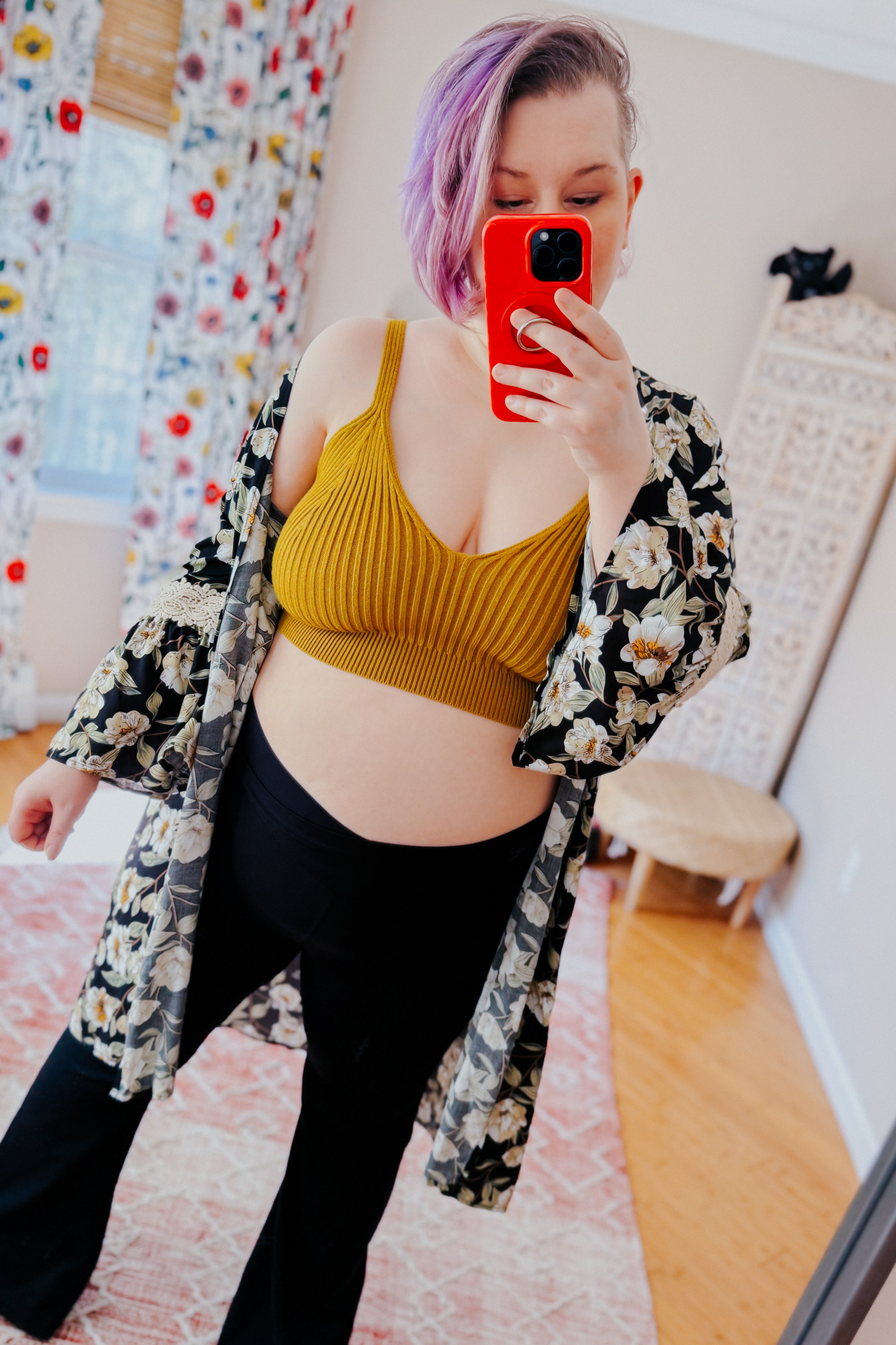 Woman with short purple hair wearing mustard hazy baby rib knit brami bralette and floral kimono taking selfie indoors
