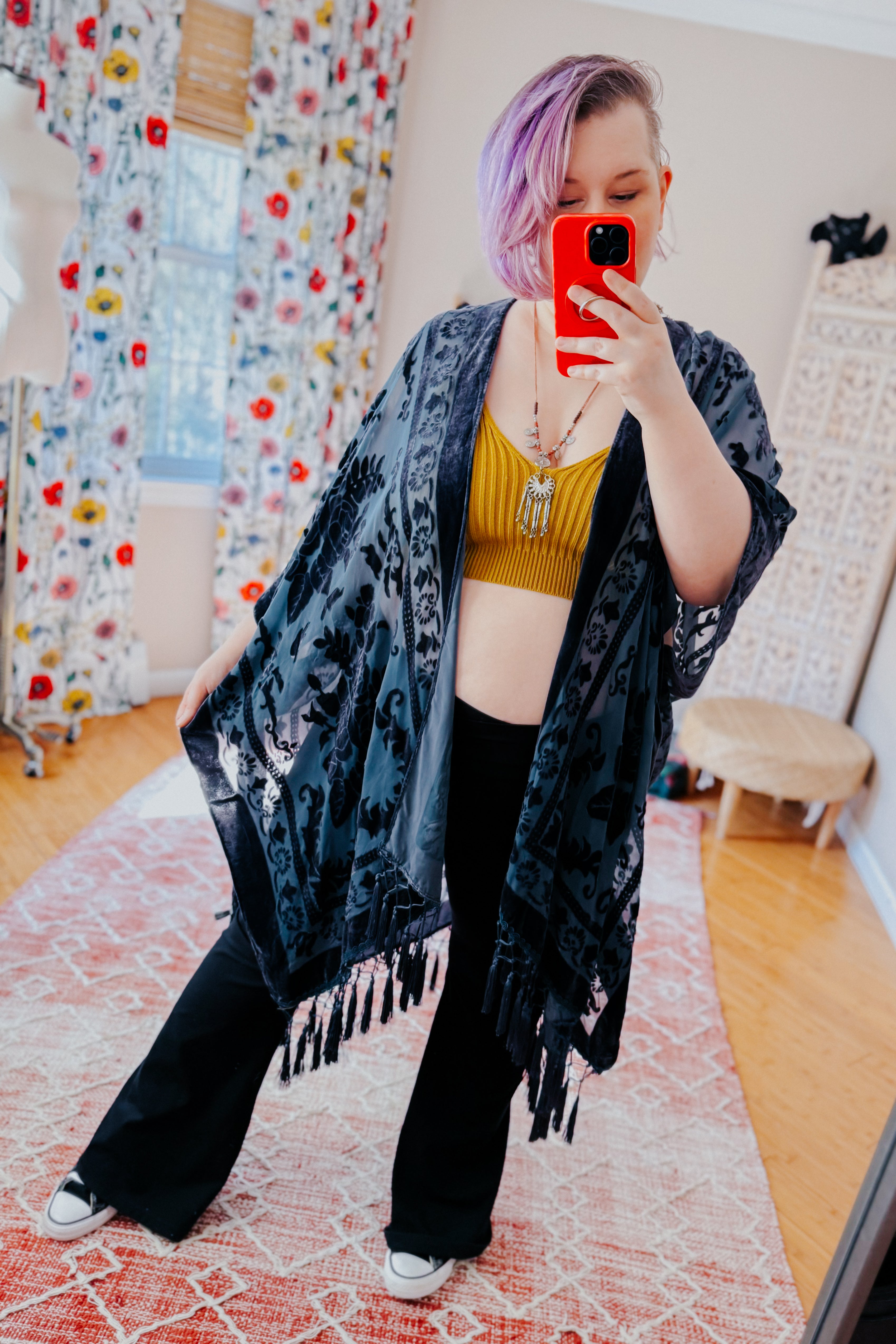 Woman taking mirror selfie wearing mustard rib knit brami bralette with black kimono and wide-leg pants indoors