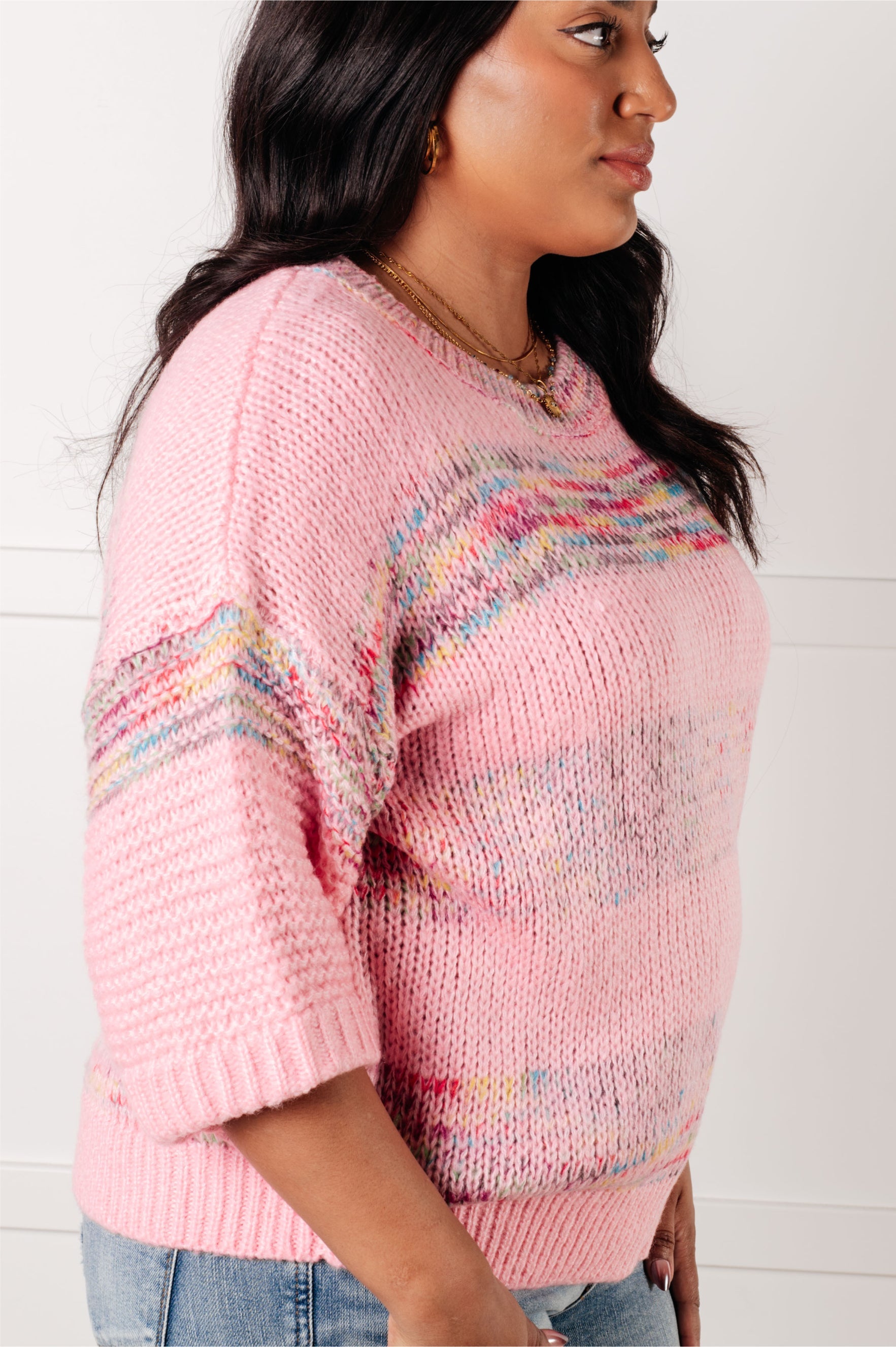 Side view of woman wearing pink In the Cards Striped Sweater with multicolor stripes and elbow-length sleeves against white background