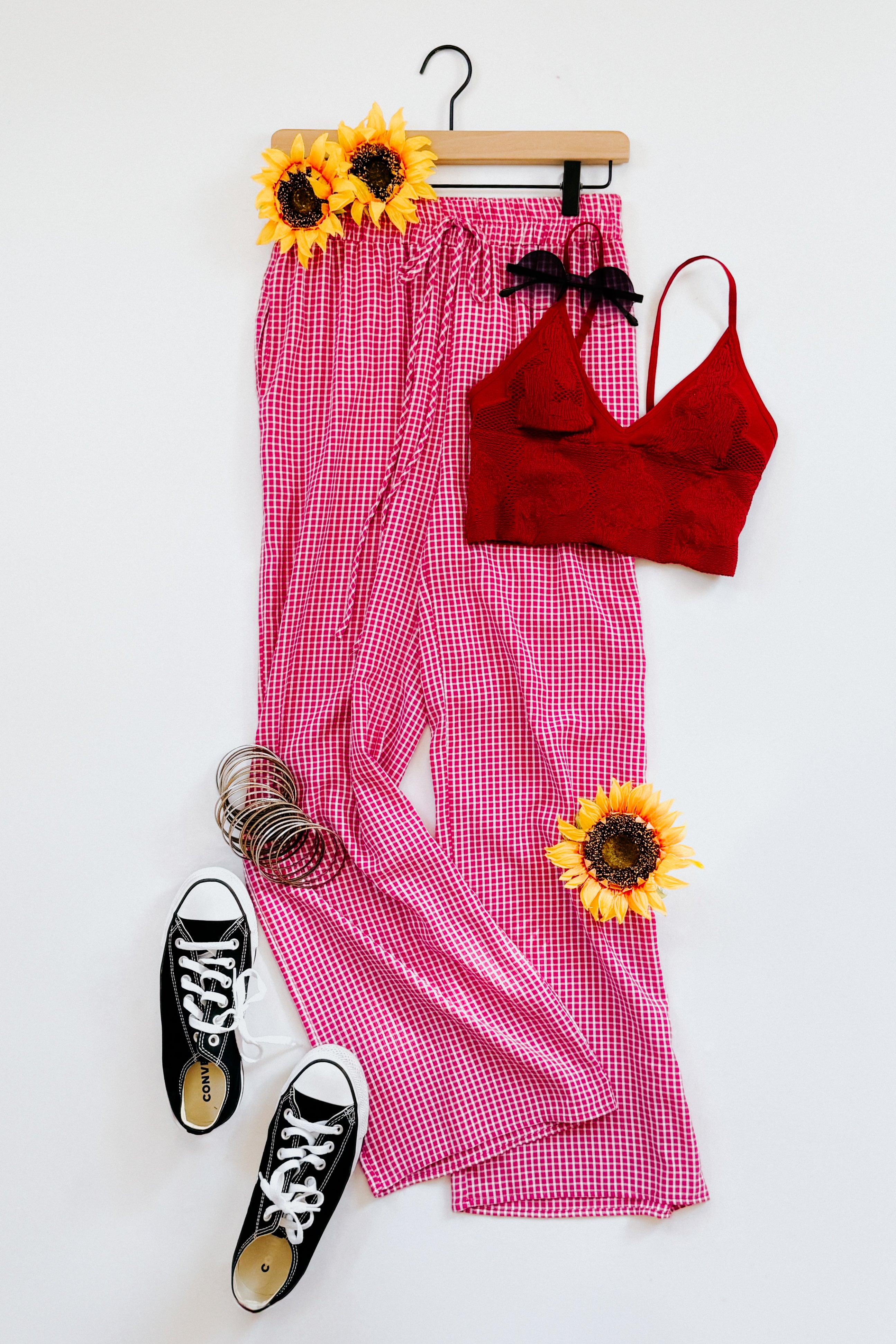 Pink In The Groove Checkered Print Pants with drawstring waist styled with red crop top, black sneakers, and sunflower accents on white background