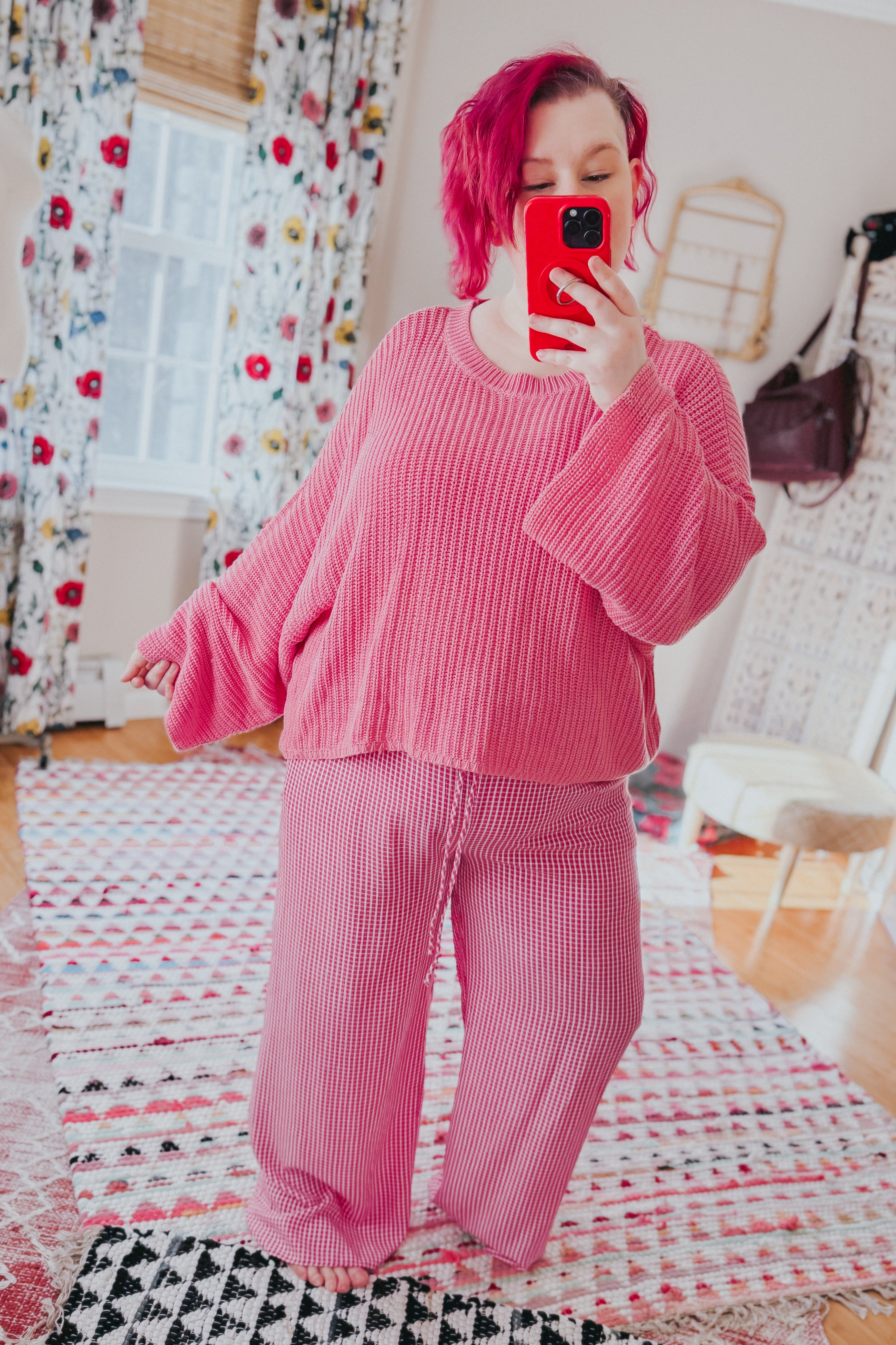 Woman taking mirror selfie wearing pink relaxed fit In The Groove Checkered Print Pants and matching textured sweater indoors