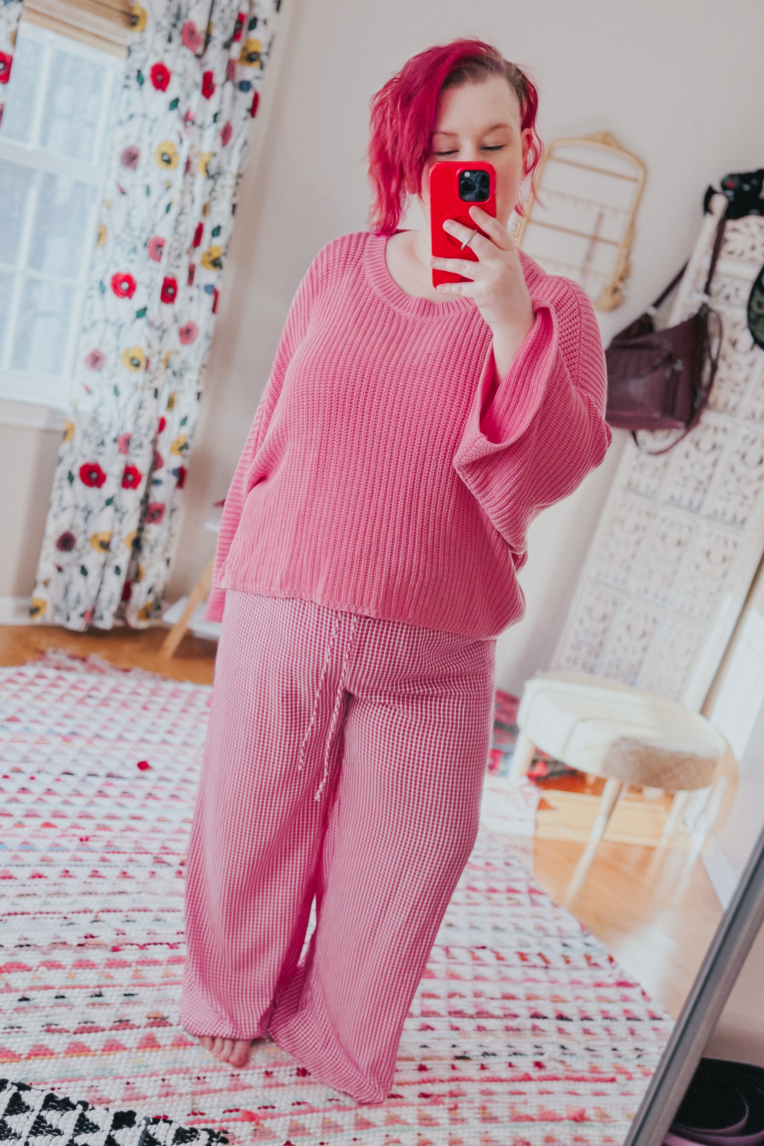 Woman wearing pink In The Groove Checkered Print Pants with wide legs and relaxed fit taking selfie in cozy bright room