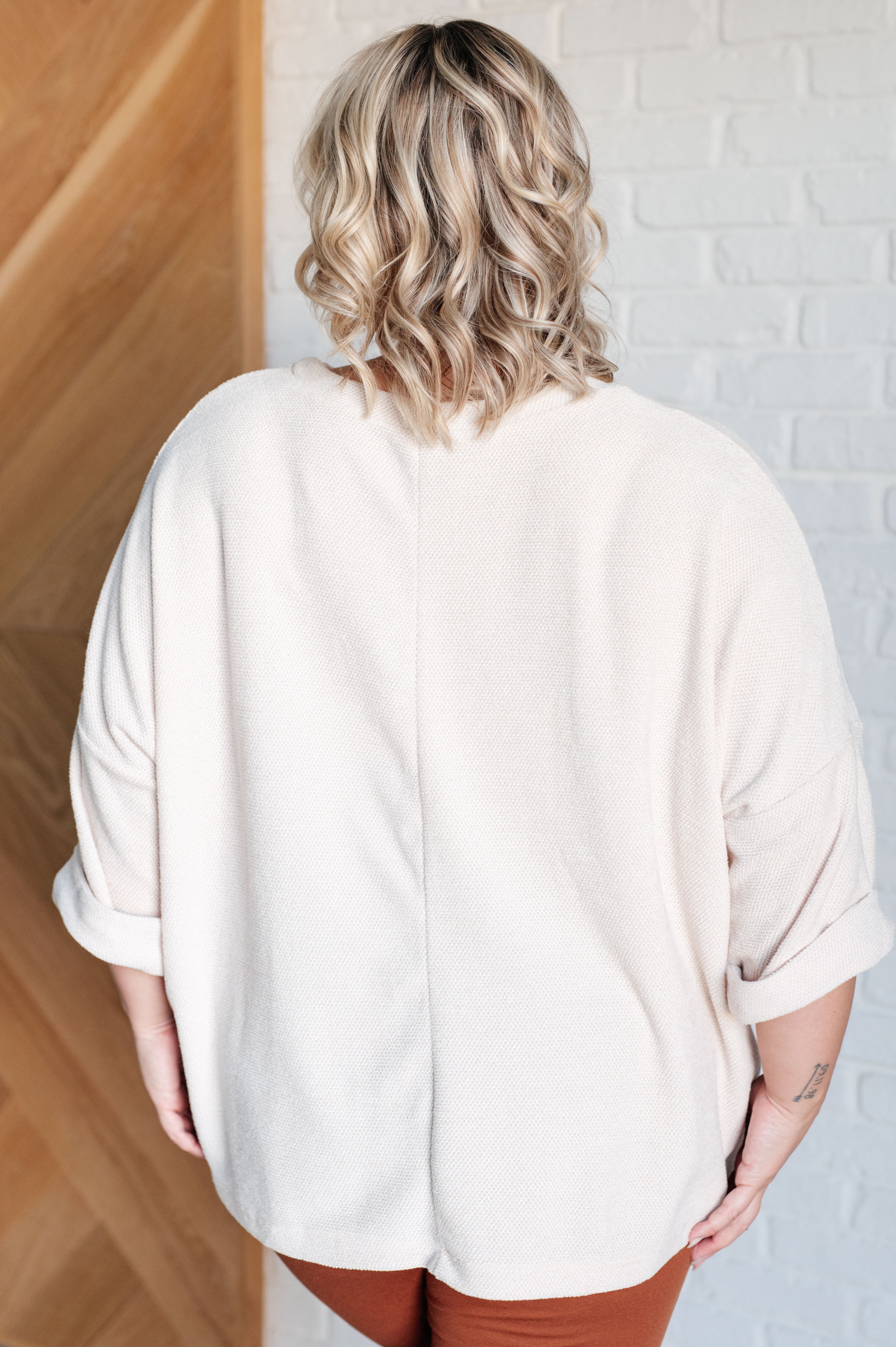 Back view of person wearing loose Ivory Thoughts chenille blouse with rolled sleeves standing indoors