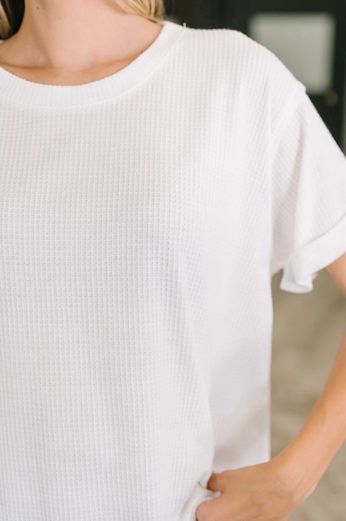Close-up of ivory waffle knit relaxed tee with short sleeves in a light and airy eclectic setting