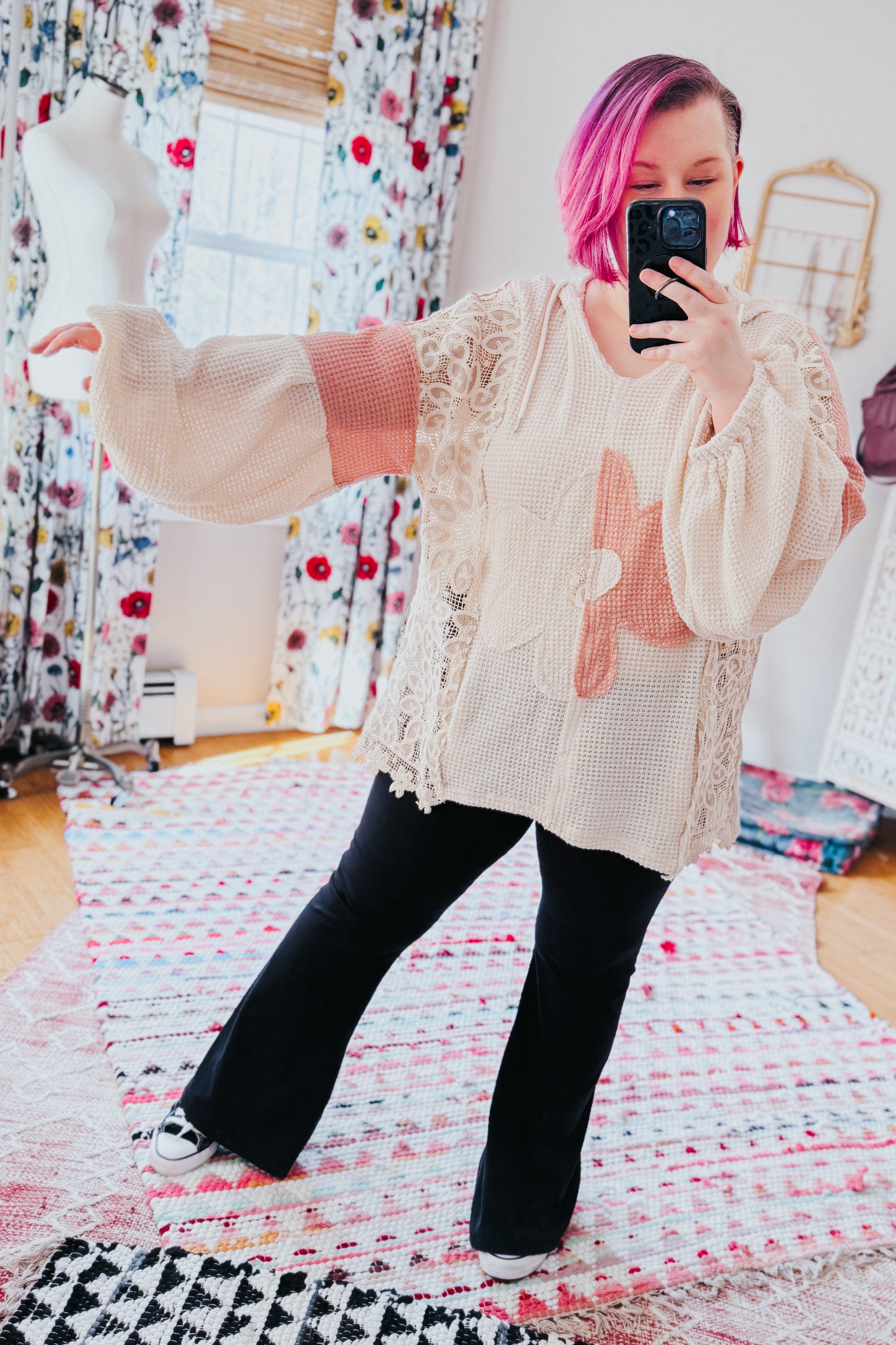 Cream textured knit top with balloon sleeves and lace panels featuring large floral appliqués worn with black pants
