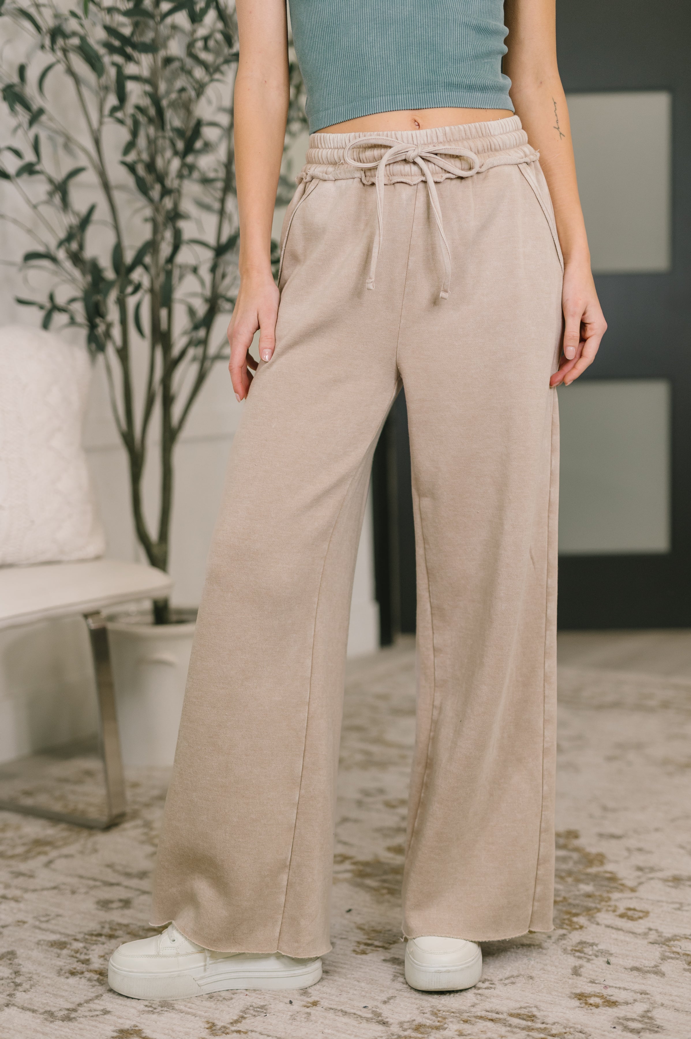 Front view of woman wearing ash mocha wide-leg palazzo sweatpants with elastic drawstring waistband indoors