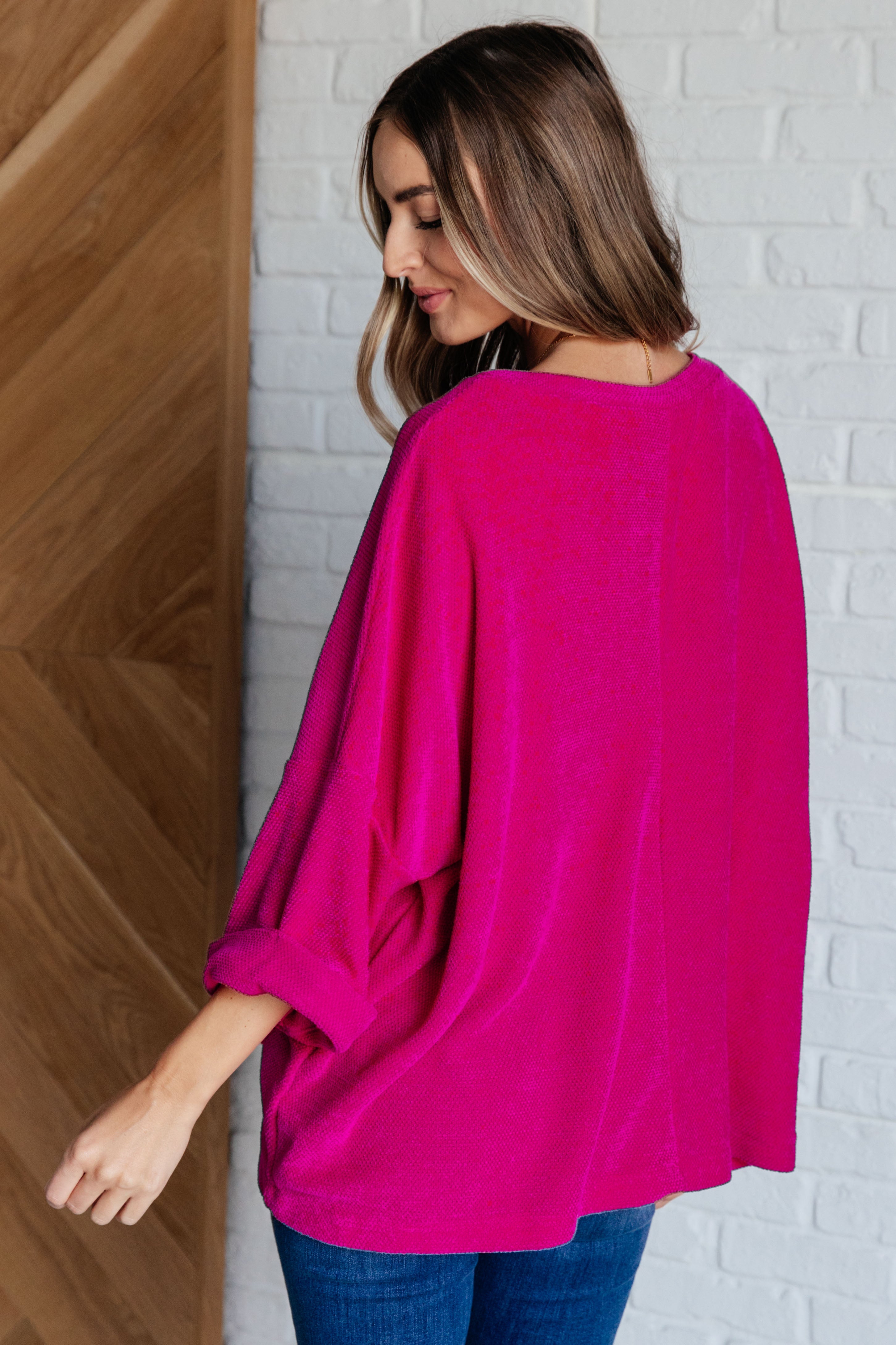 Woman wearing oversized fuchsia chenille blouse with rolled sleeves in eclectic, free-spirited, size-inclusive style