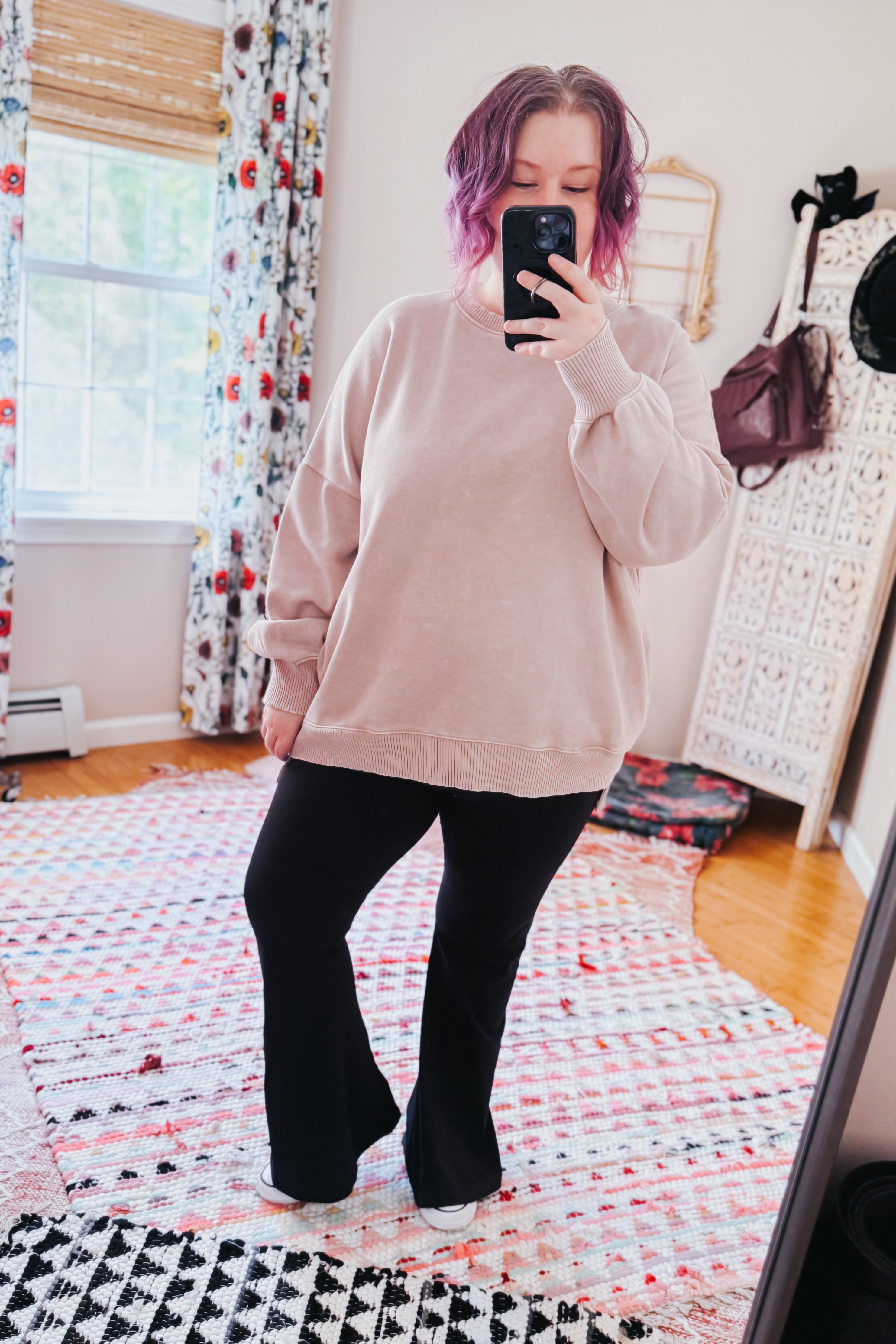 Woman taking mirror selfie wearing ash mocha oversized pullover with relaxed fit and black flared pants indoors