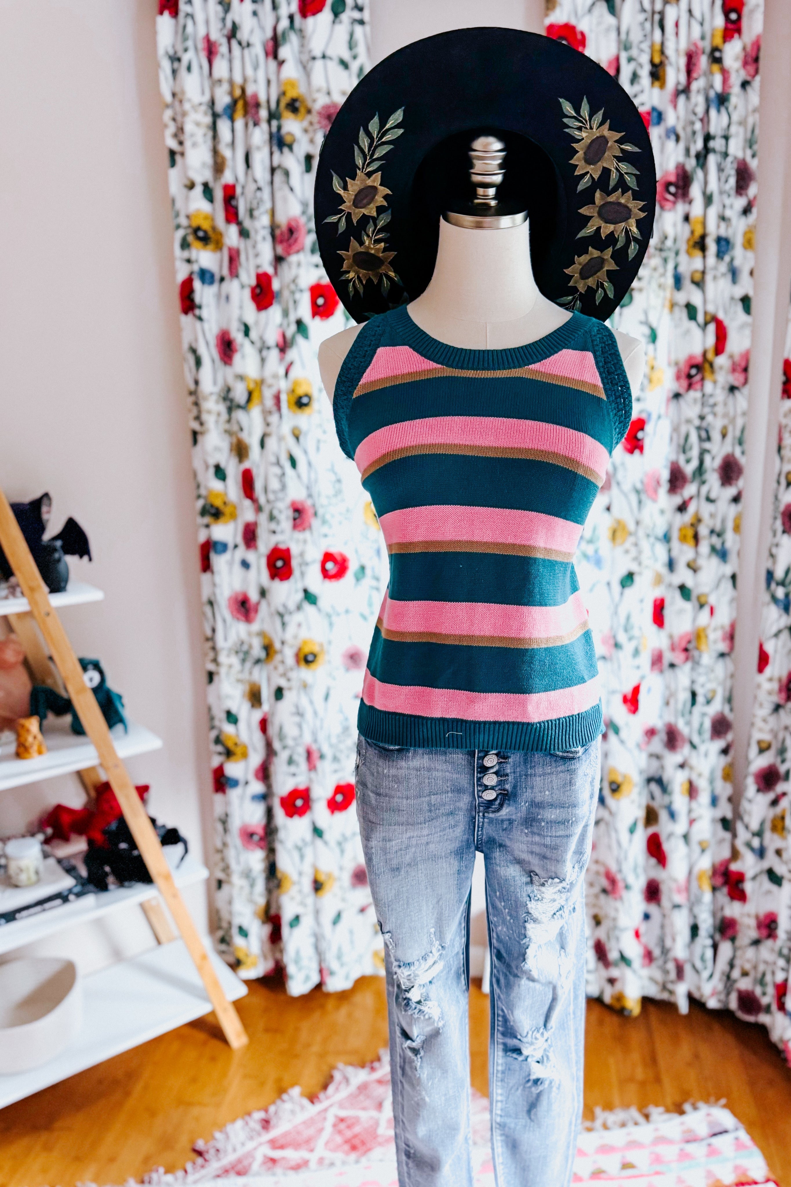 Mannequin dressed in blue and pink striped knit tank top paired with distressed light blue jeans indoors