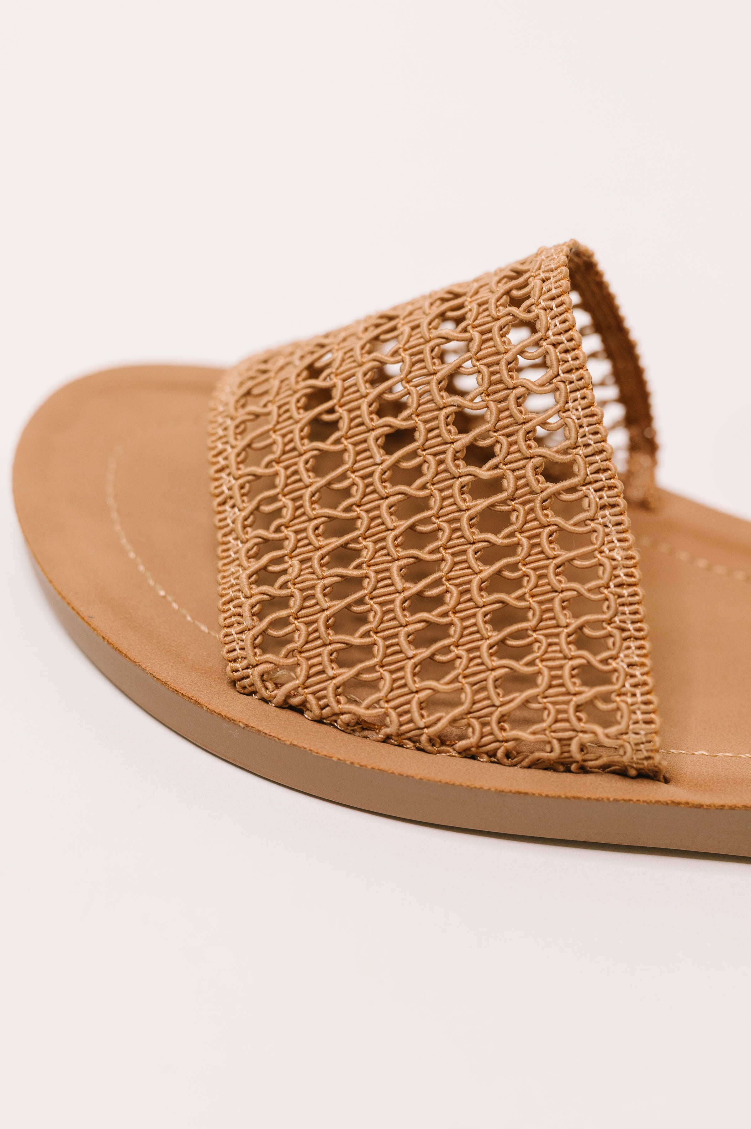 Close-up of camel sandal featuring woven strap and soft cushioned sole in a relaxed style