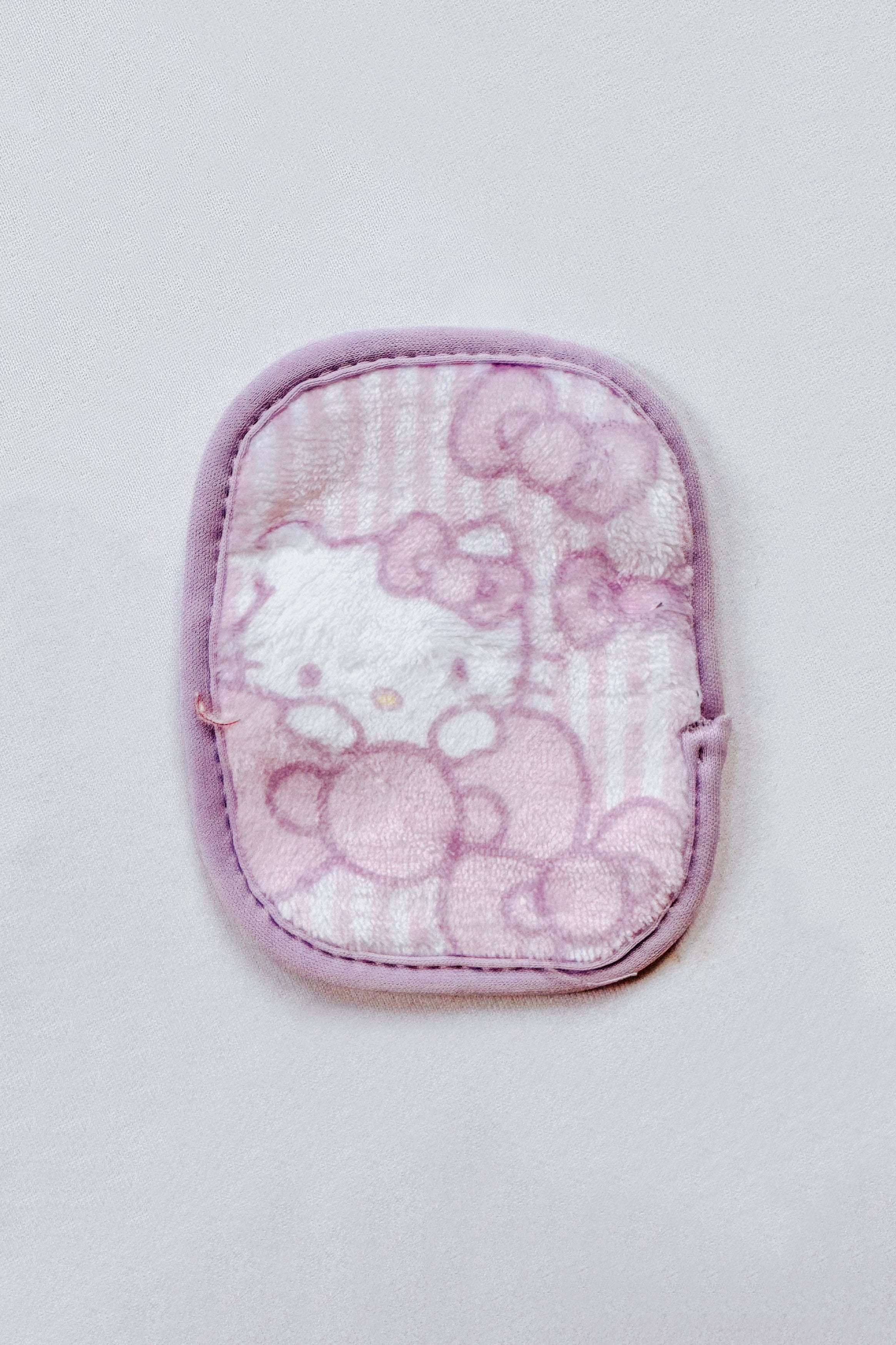 Small soft makeup remover cloth with Hello Kitty design in pastel purple and pink tones