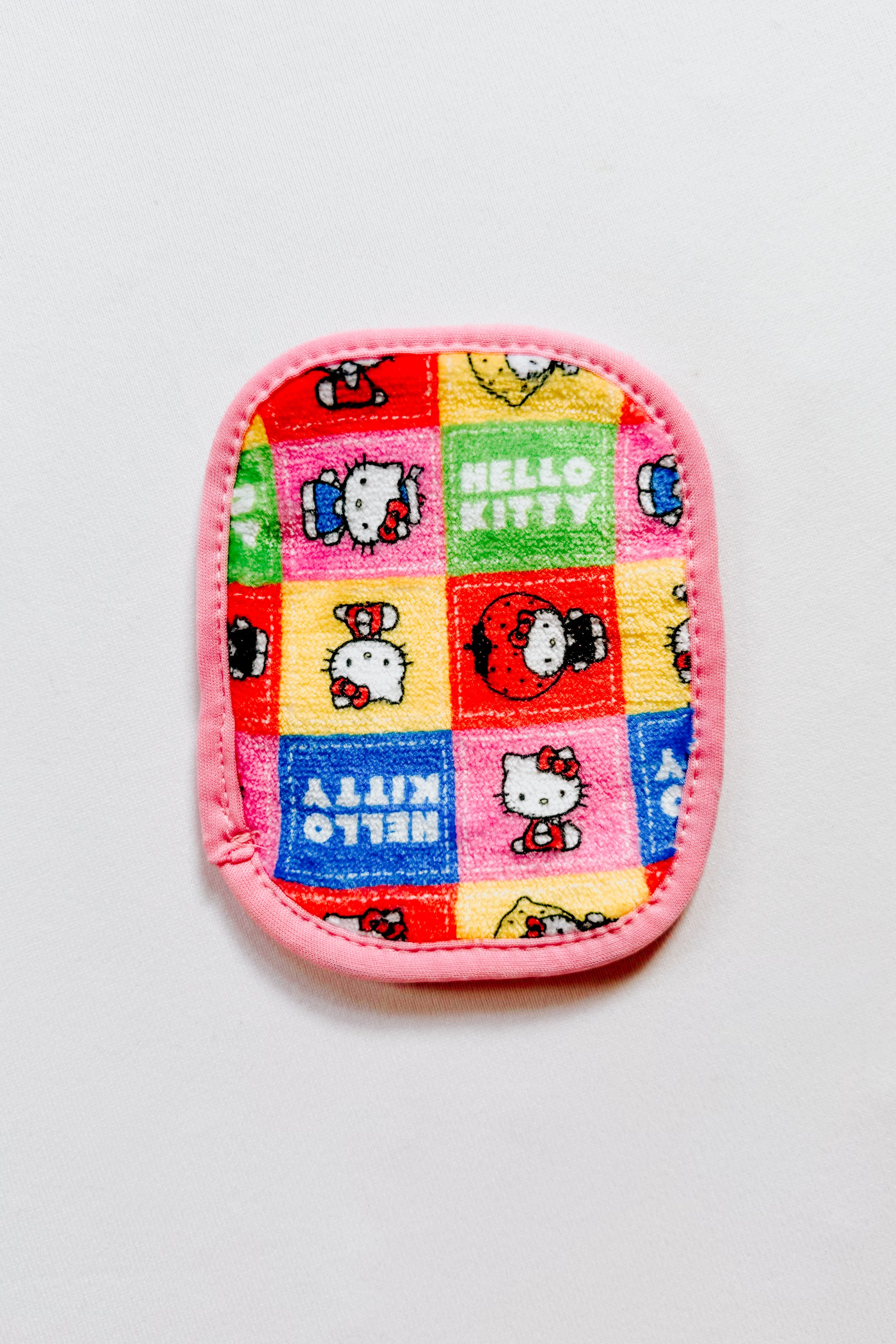 Small microfiber makeup eraser pad with red, pink, yellow, green, and blue Hello Kitty squares and pink trim