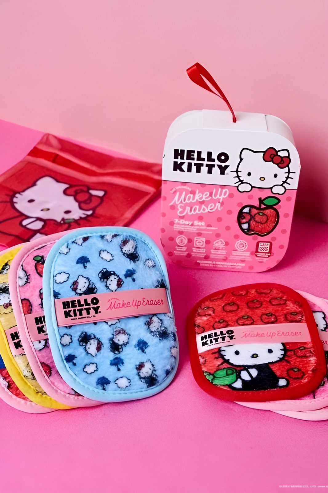 Colorful set of Hello Kitty makeup remover pads in red, yellow, pink, and blue with matching storage pouch on pink background