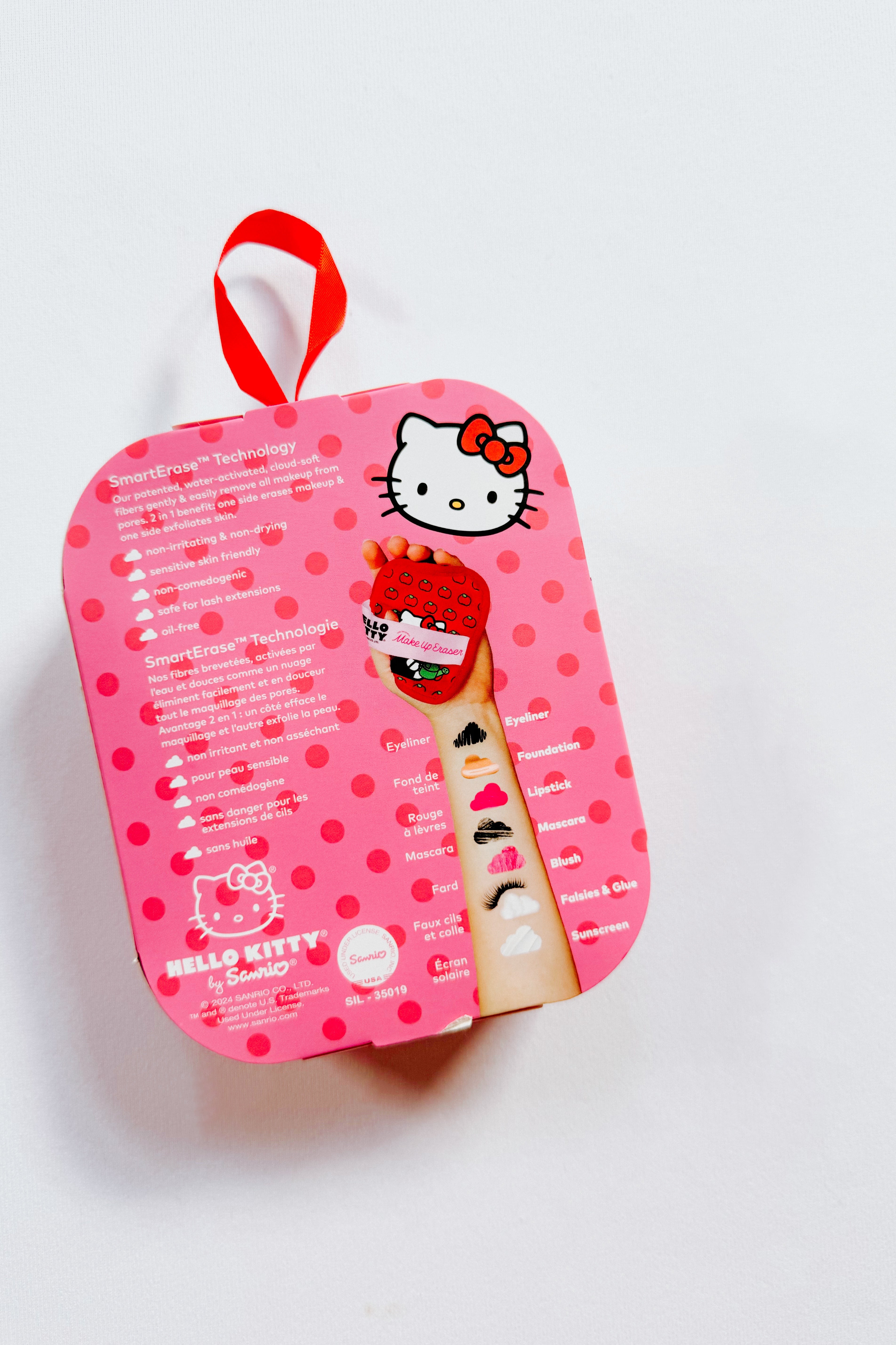 Pink polka dot Hello Kitty makeup eraser packaging with arm swatches of various makeup products displayed