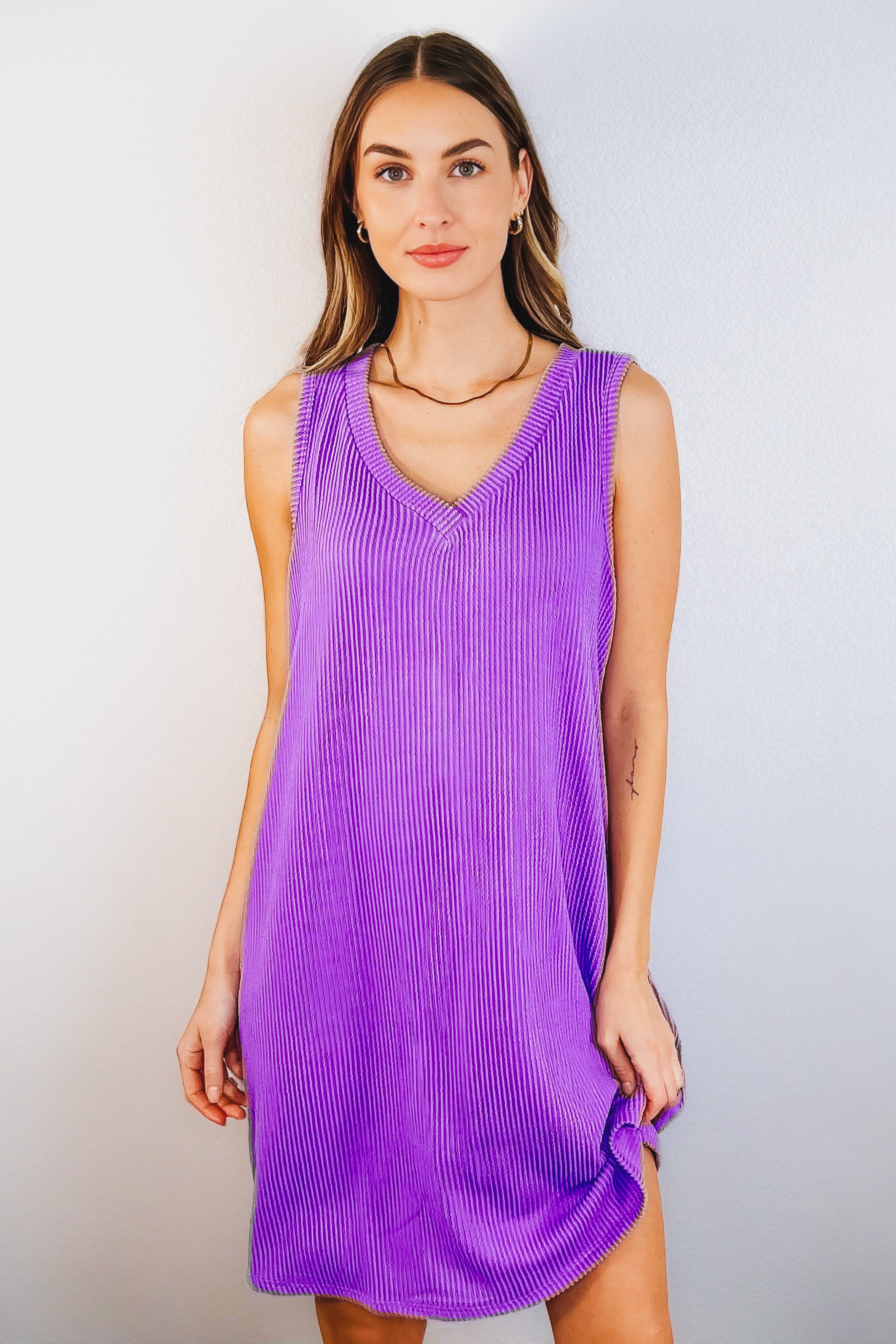 Woman wearing tropical violet ribbed knit sleeveless dress with V-neck and relaxed fit against white background