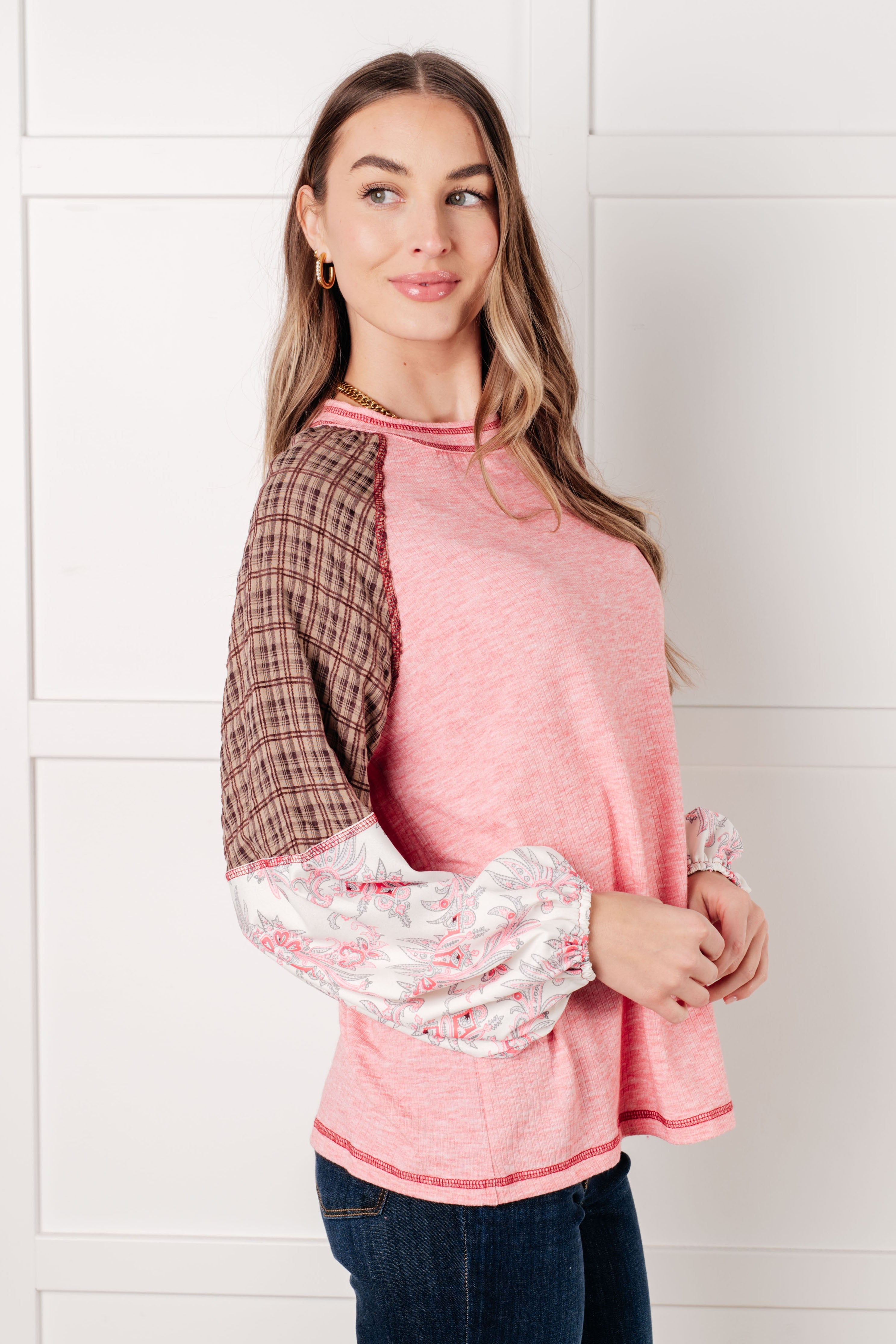 Woman wearing pink Walk for Miles top with brown plaid upper sleeves and floral puffed lower sleeves facing sideways