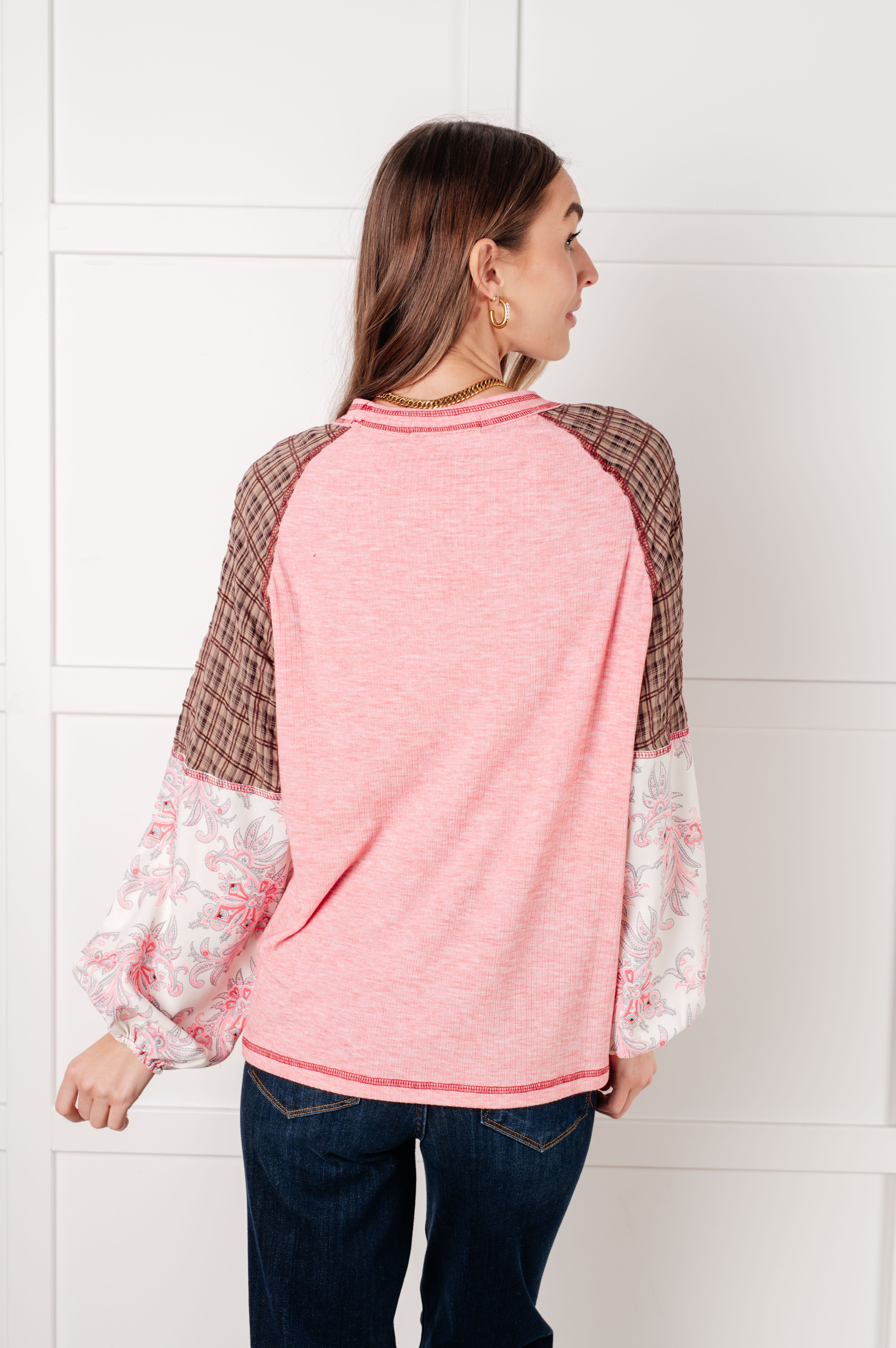 Woman shown from behind wearing Walk for Miles top with pink back, brown plaid upper sleeves, and floral lower sleeves