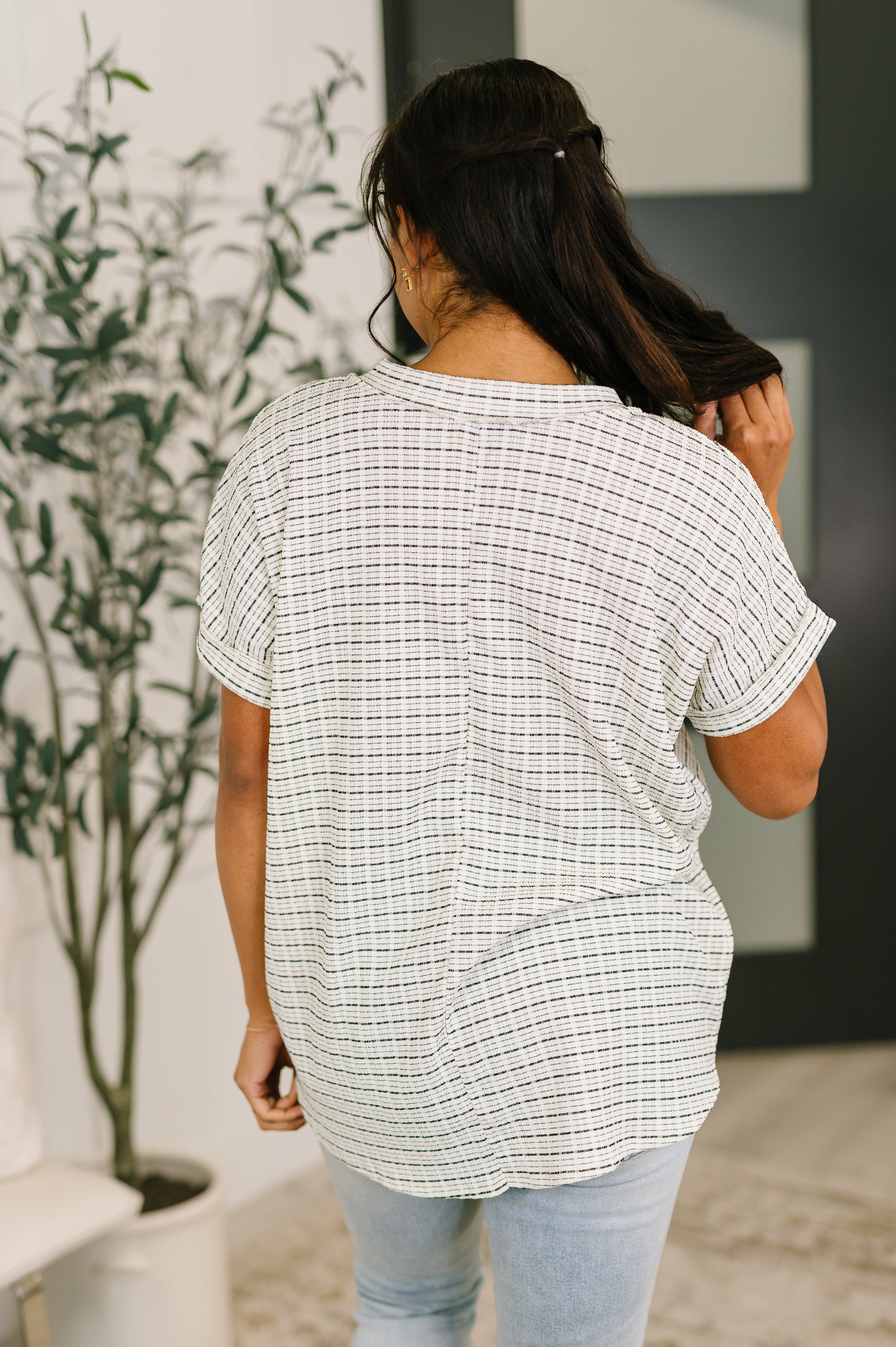 Back view of cream textured knit top with short sleeves and relaxed fit in a free-spirited, eclectic style setting