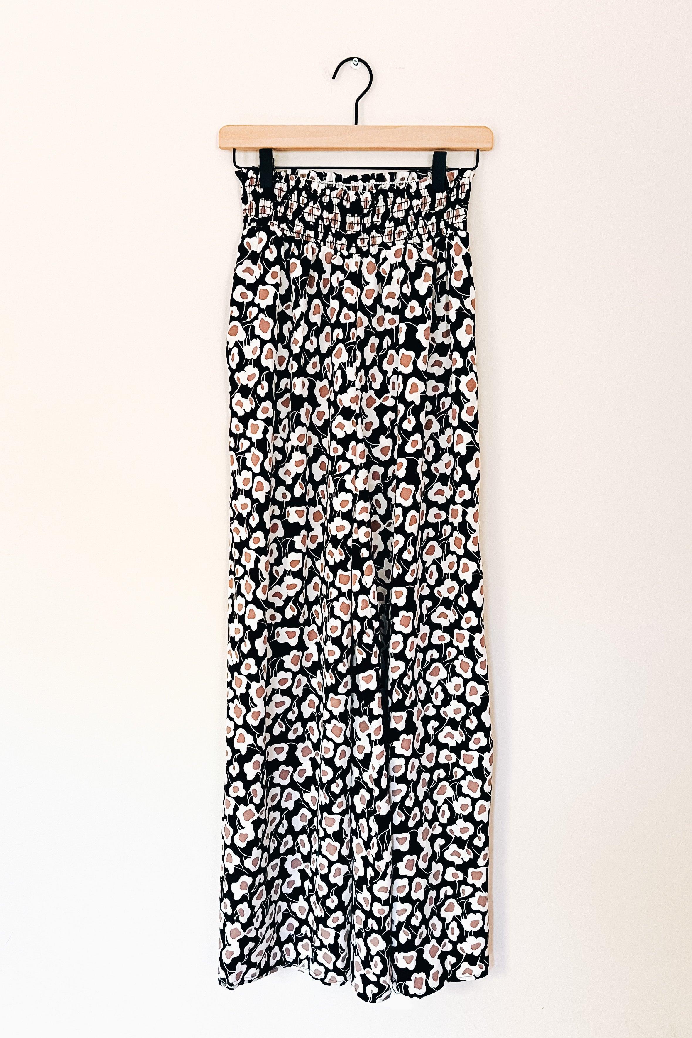 Flowers In Your Hair Retro Vintage Print Smocked Pants in black ivory with smocked waistband hanging against white background