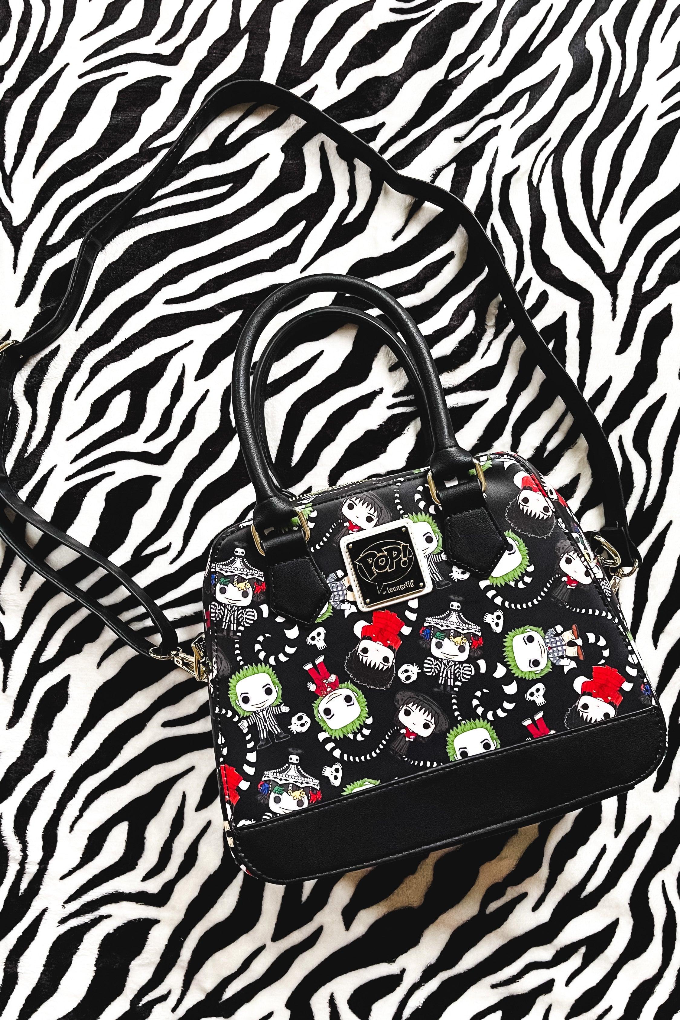 Black loungefly handbag with colorful beetlejuice character faces and skeleton motifs on a black and white zebra print background