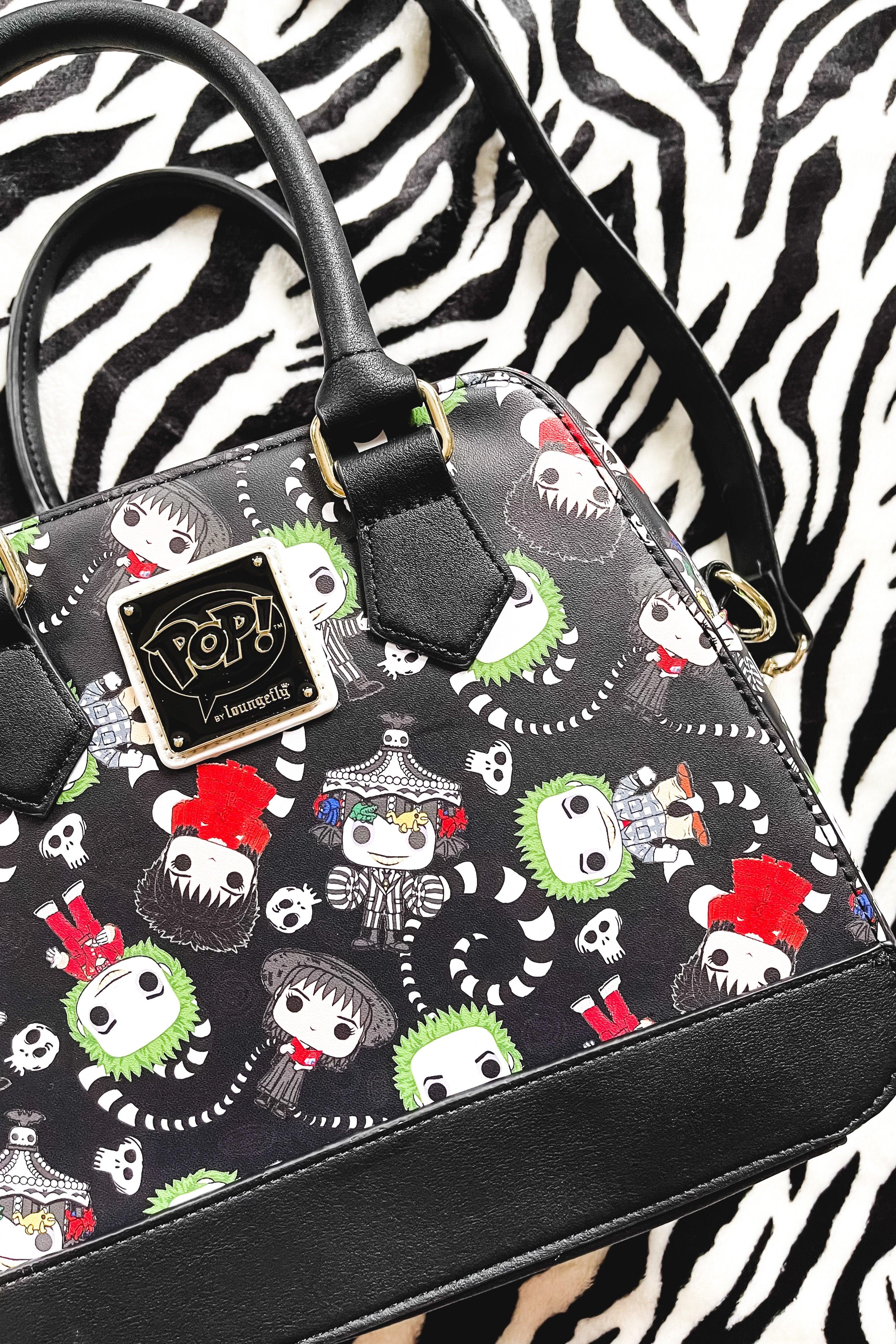 Black loungefly handbag with cartoon beetlejuice faces in red, green, and white on black background with black trim and handles