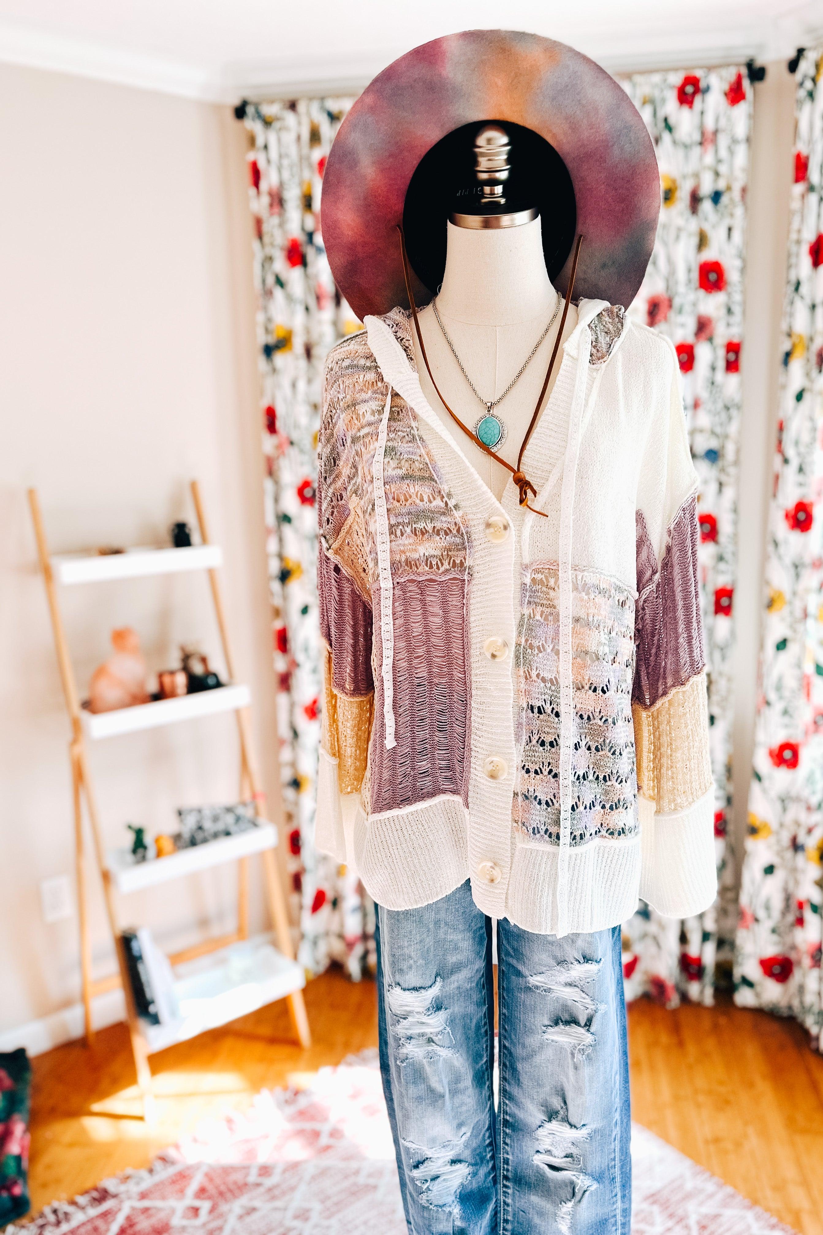 Lightweight lavender and cream open-knit cardigan with mixed textured panels, button front, and hood styled with layered necklaces