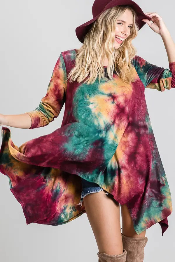 Flowy long-sleeve tunic with vibrant ruby tie-dye pattern, styled with denim shorts and a wide-brimmed hat