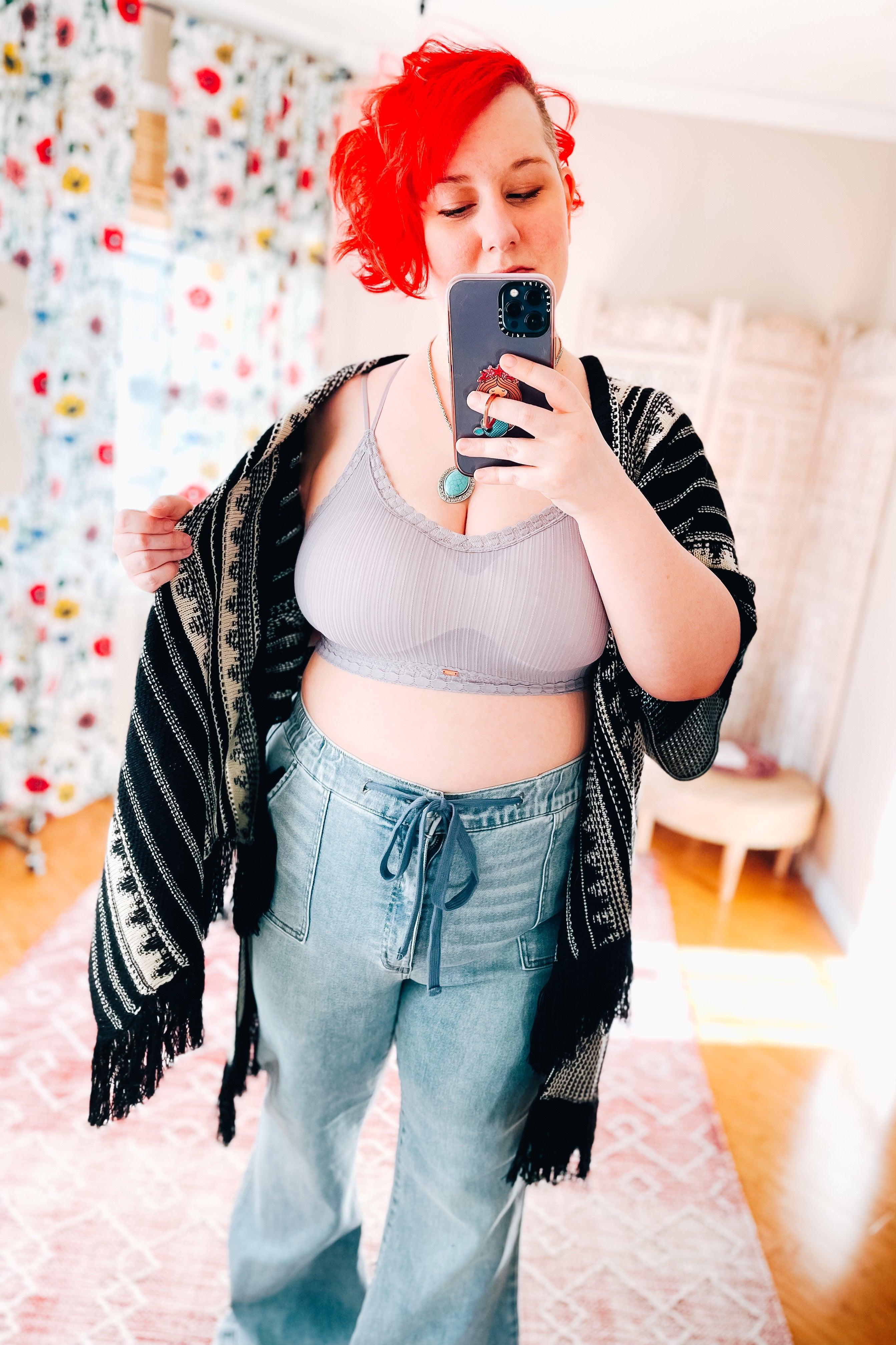 Curved ribbed lilac bralette with lace trim, worn with high-waisted denim pants and a black-and-white patterned shawl