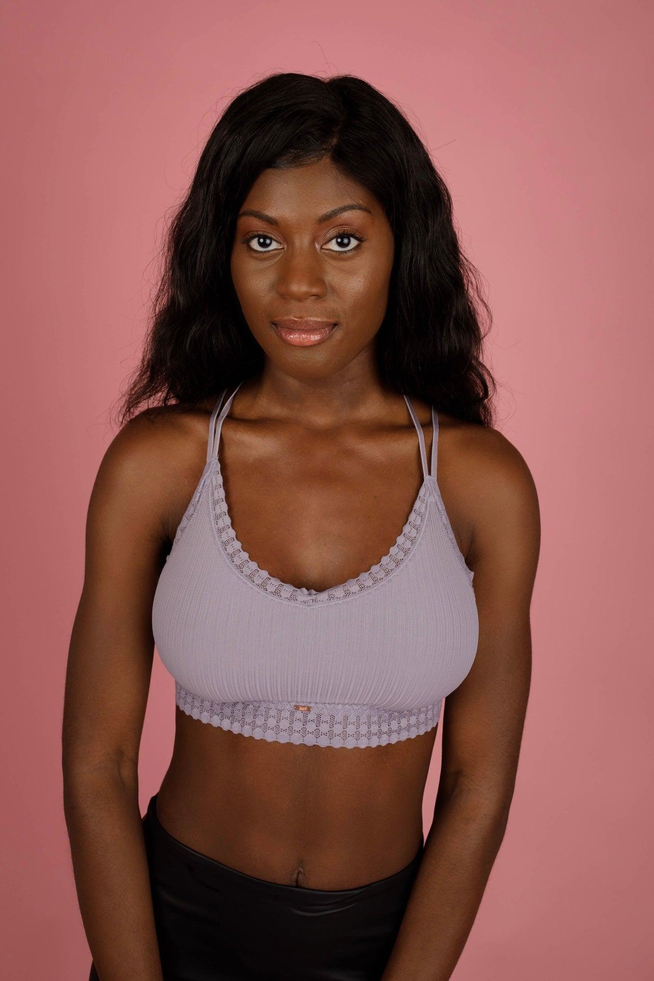 Woman wearing a lilac ribbed lace bralette with double thin straps against a soft pink background