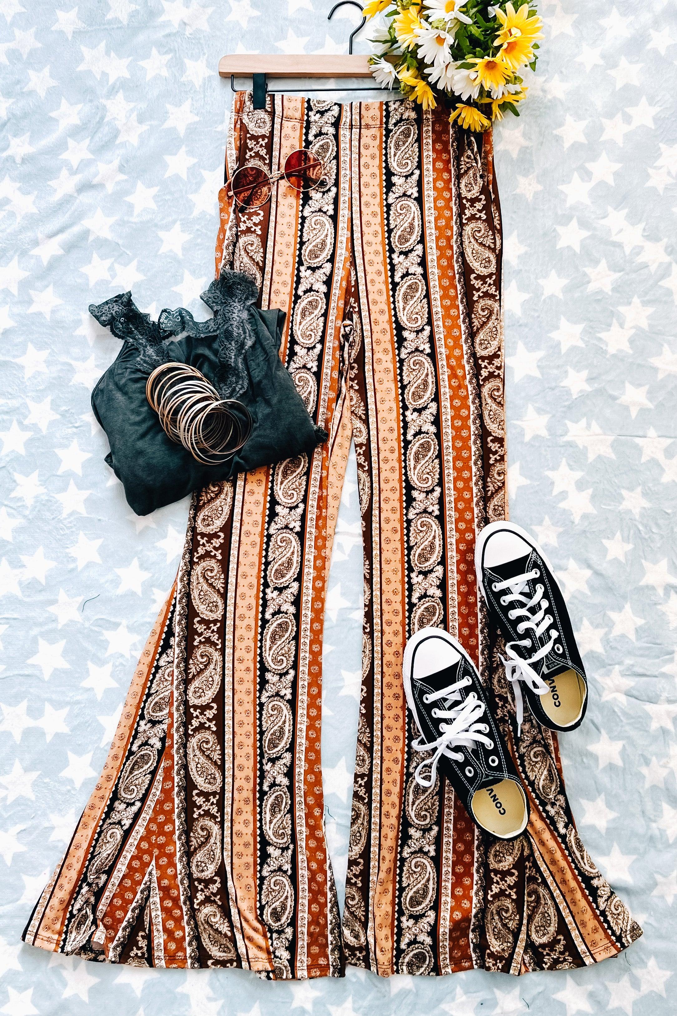 Rust paisley striped flared pants styled with black lace top, bangles, sunglasses, and black Converse on star-patterned backdrop