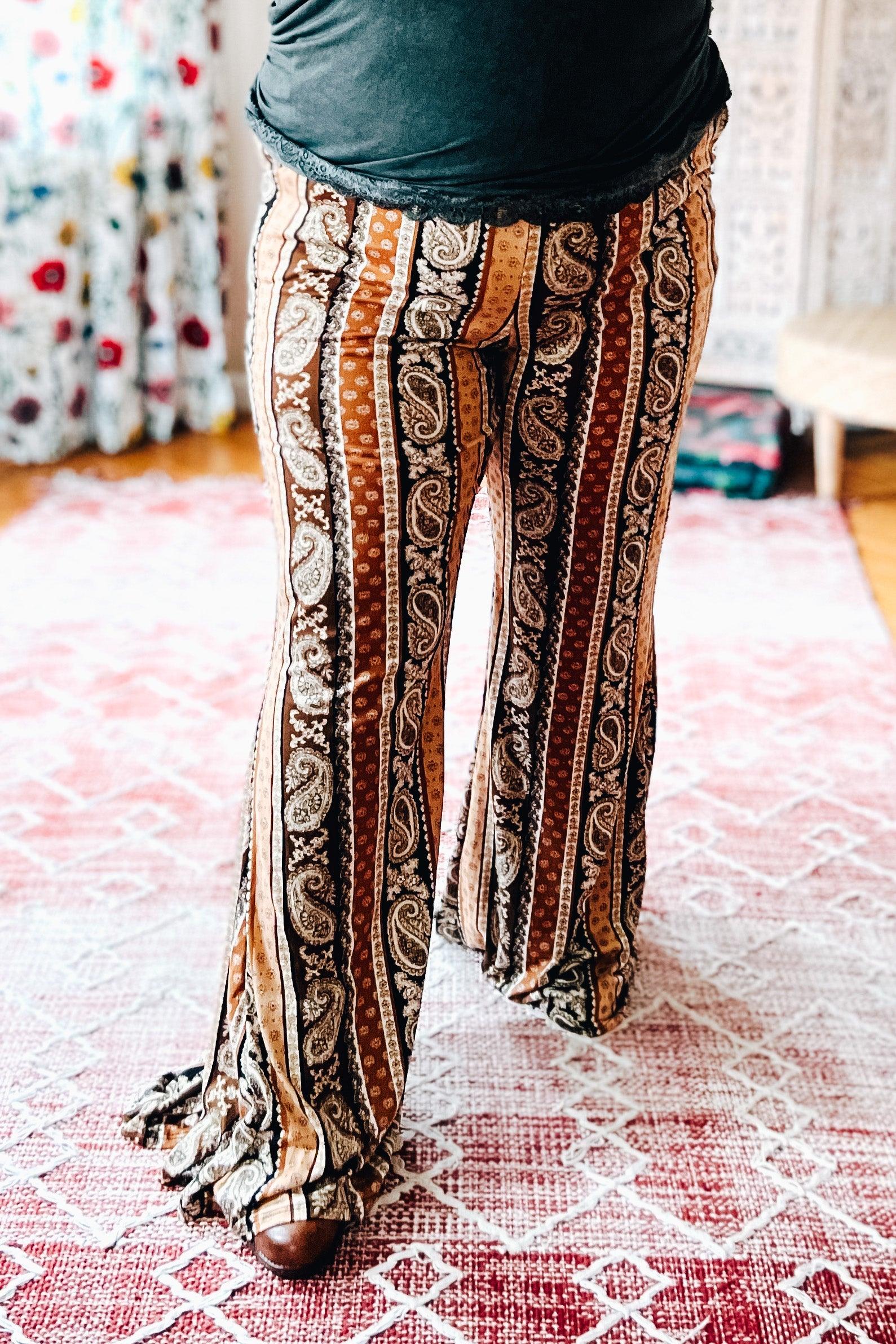 Rust paisley print flared pants styled in a cozy home setting with a warm, eclectic vibe