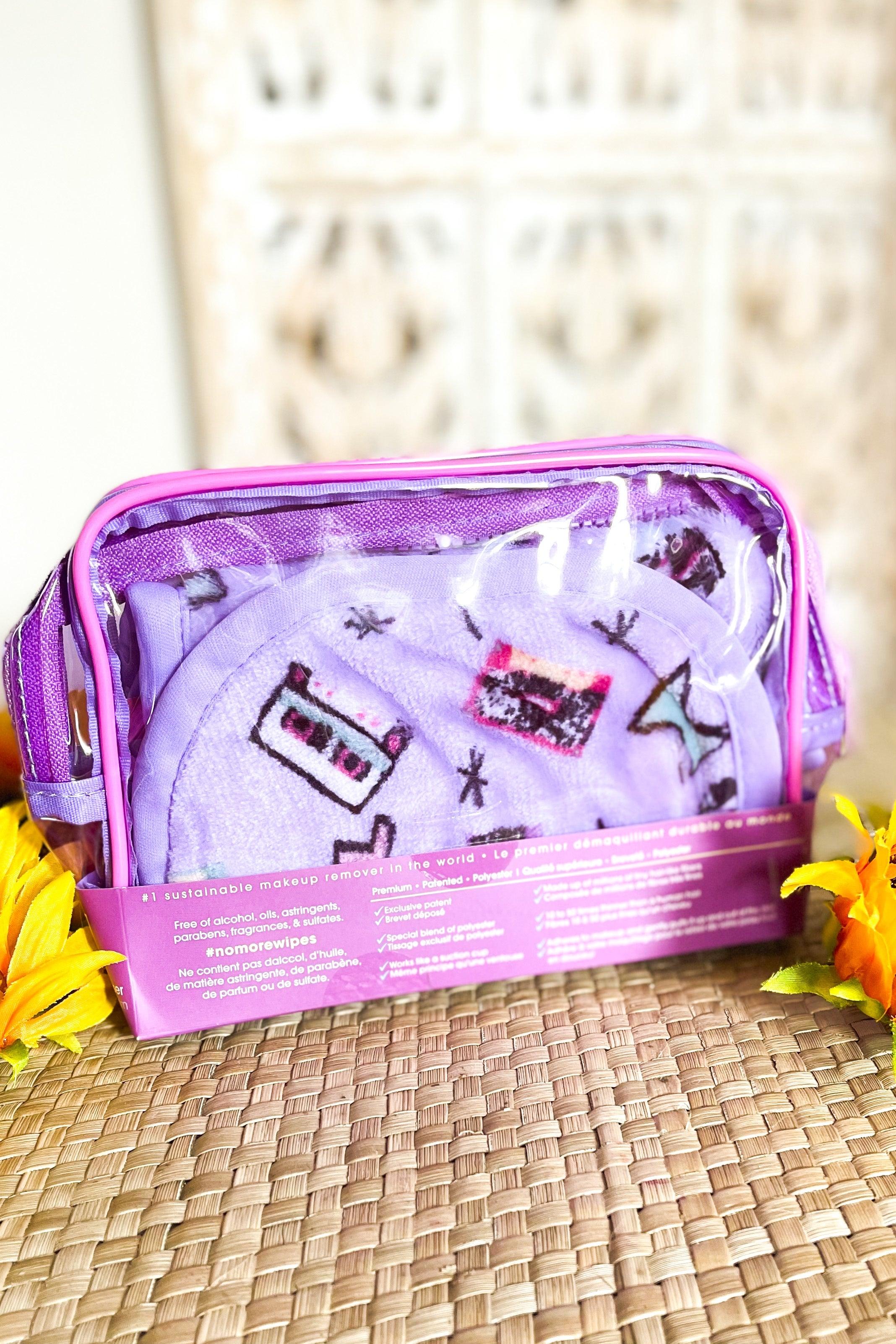 Purple makeup remover set with cassette tape print packaged in clear travel pouch on woven surface with yellow flowers